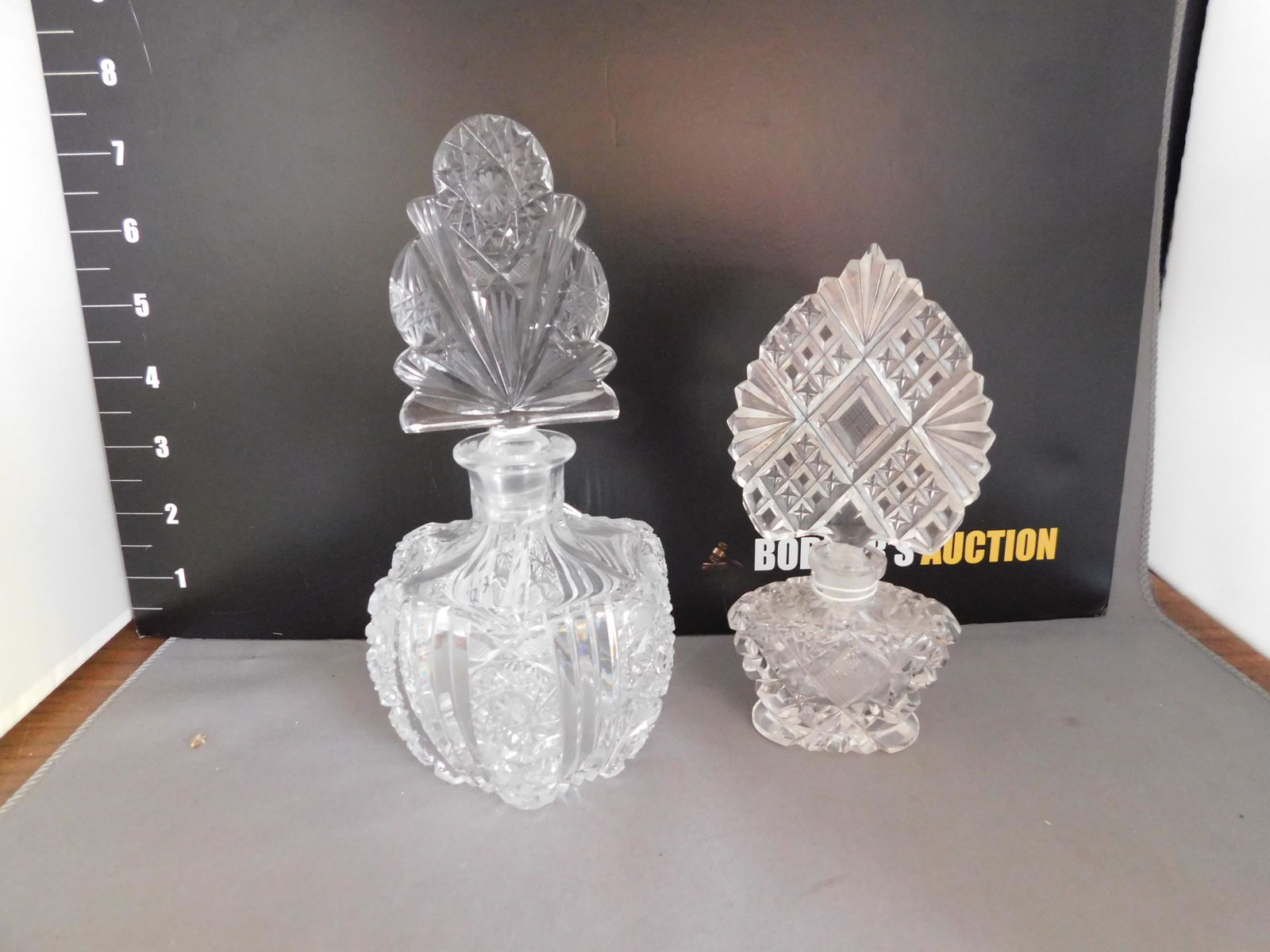 Pair Art Deco Crystal Perfume Bottles: Pair Art Deco Cut Crystal Perfume Bottles. The tallest measures approx. 7" tall. You are bidding at a live sale, please read the terms and conditions. We are offering contact-less pick ups at our Sout