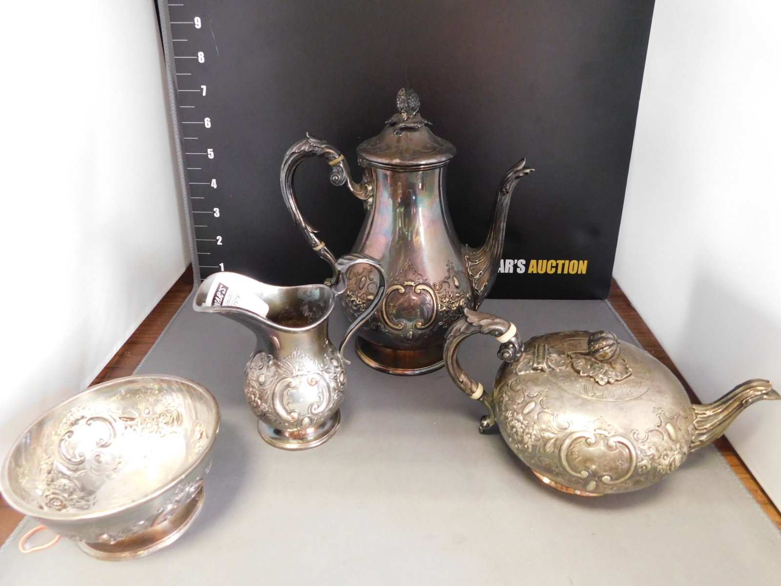 Silverplate Ornate French Tea Service: Small Ornate French Style Tea Service. Silverplate on Copper. 4 Piece Set. Teapot measures 8" tall. You are bidding at a live sale, please read the terms and conditions. We are offering contact-less p