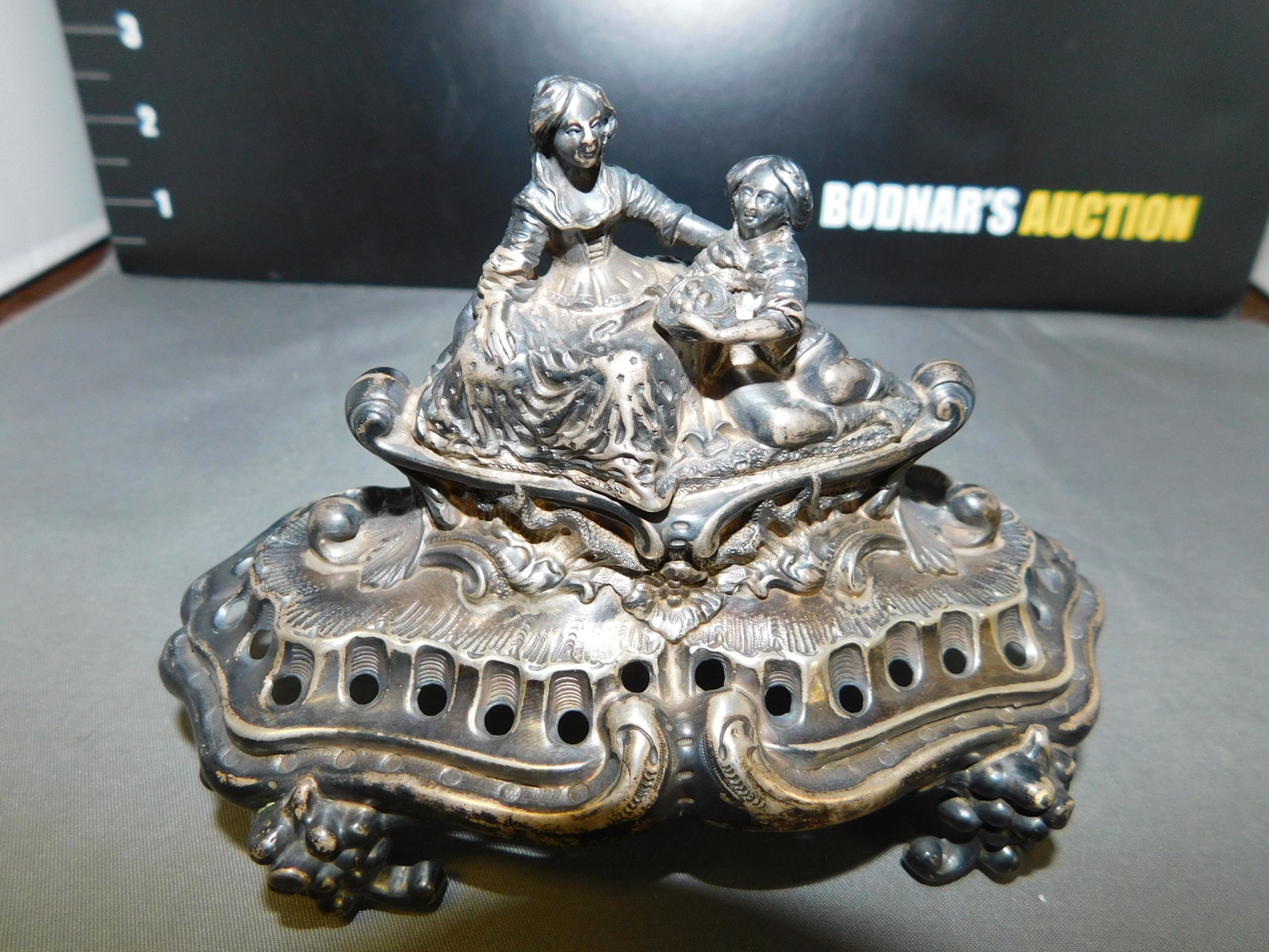 Sterling Topper: Sterling Topper of 2 People Sitting. Measures approx. 4" t x 5.5" w. You are bidding at a live sale, please read the terms and conditions. We are offering contact-less pick ups at our South Brunswick 