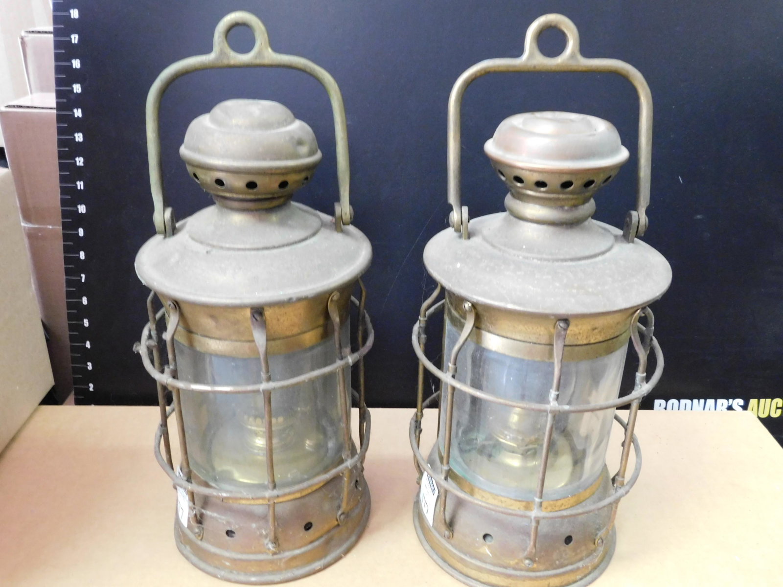 Pair of Ship Lanterns: Pair of Ship Lanterns. Copper and Brass. Measures approx. 17" tall. You are bidding at a live sale, please read the terms and conditions. We are offering contact-less pick ups at our South Brunswick l