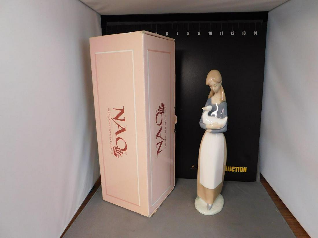 Nao Figurine of Girl Holding Goose: Nao Figurine #25 Girl holding Goose. Comes with Box. Measures 11" tall. You are bidding at a live sale, please read the terms and conditions. We are offering contact-less pick ups at our South Brunswi