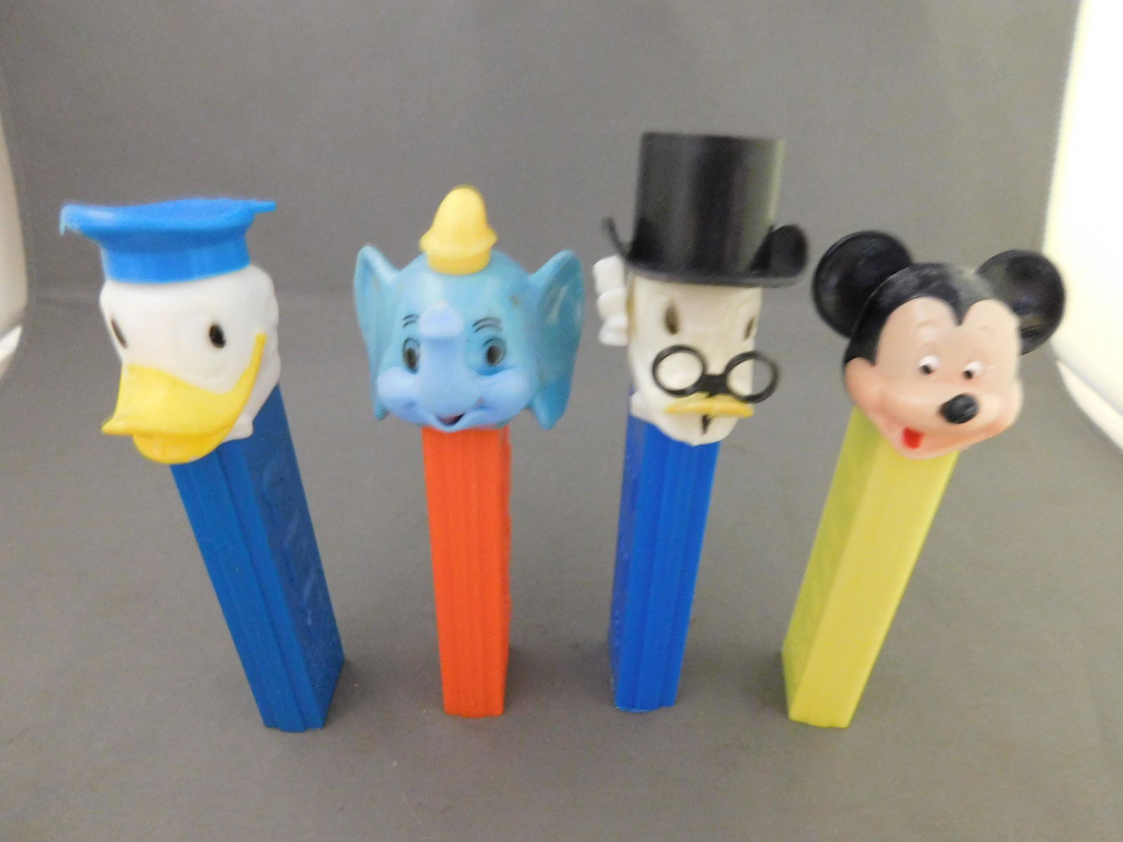 Disney Vintage Pez Lot of 4 - Scrooge, Donald, Dumbo,: Disney Vintage Pez Lot of 4. All have no feet. Included in this lot are Scrooge and Donald Duck Made in Hong Kong, Dumbo Made in Austria and Mickey with Yellow Body Made in Austria. You are bidding at