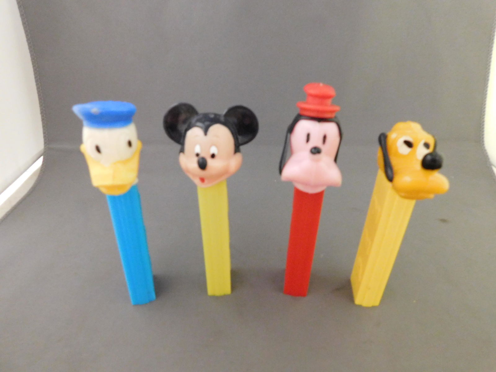 Disney Vintage Pez Lot of 4 - Goofy, Mickey, Donald,: Disney Vintage Pez Lot of 4. They all have no feet. Included in this lot are Goofy and Mickey with yellow body made in Austria, Donald Duck made in Hong Kong and Pluto with yellow body made in USA. Yo