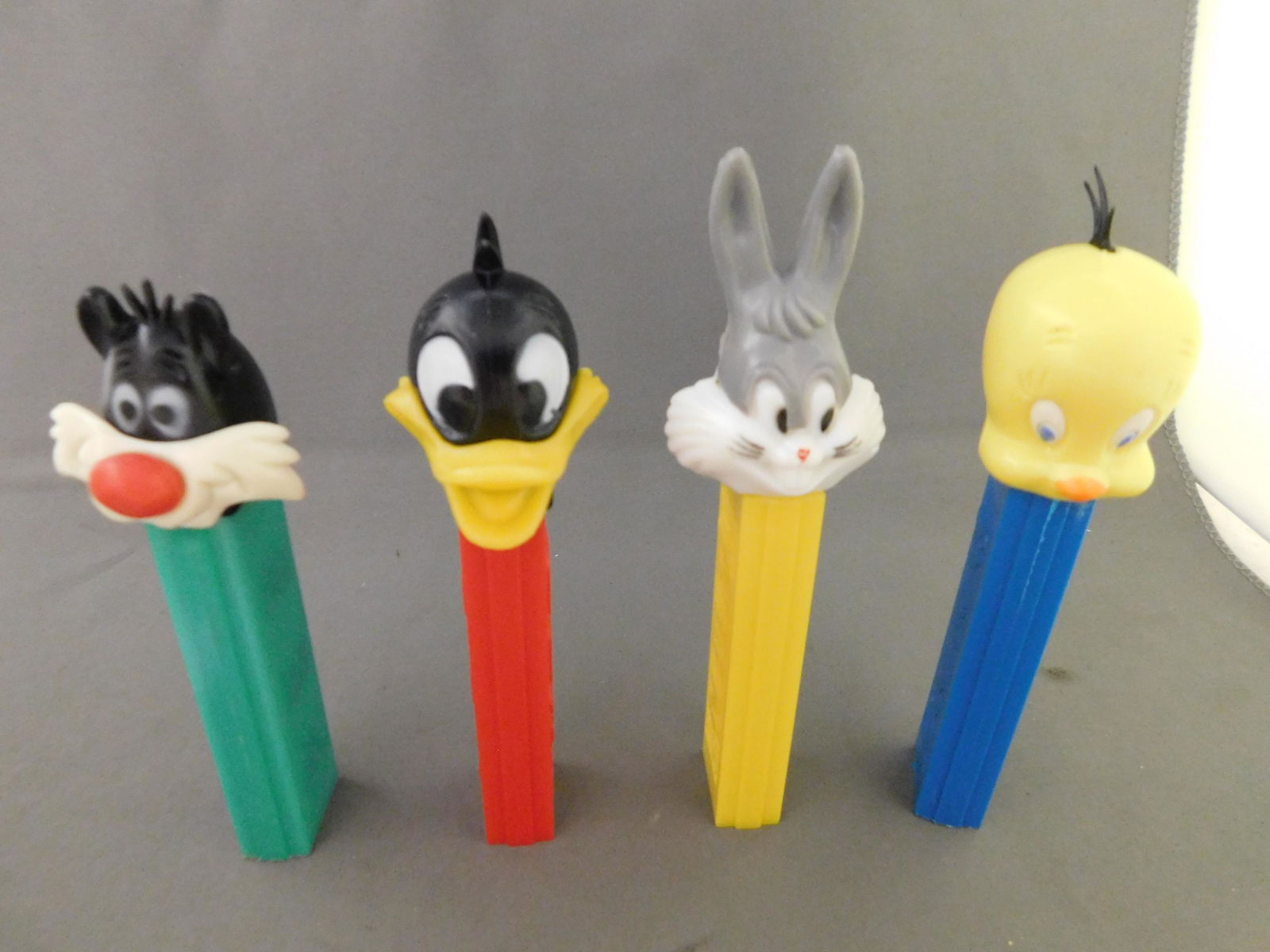 Looney Tunes Vintage Pez Lot of 4: Looney Tunes Vintage Pez Lot of 4. They all have no feet. Included in this lot are Bugs Bunny, Sylvester, Daffy Duck, and Tweety. All are made in Hong Kong. You are bidding at a live sale, please read