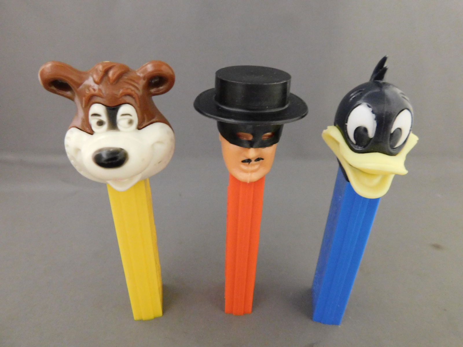Mixed Vintage Pez Lot of 3: Mixed Vintage Pez Lot of 3. They all have no feet. Included in this lot are Barney Bear Made in Hong Kong and Zorro and Daffy Duck made in Austria. You are bidding at a live sale, please read the term
