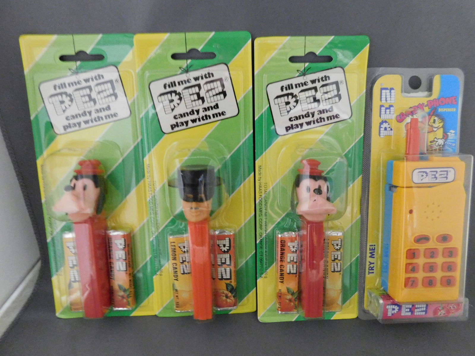 Goofy and Zorro Pez in Package Lot: Lot of 2 Goofy Pez in Striped Packaging and 1 Zorro Pez in Striped Packaging. All with no feet. Also included in this lot is a Pez Candy Phone in Package. You are bidding at a live sale, please read t