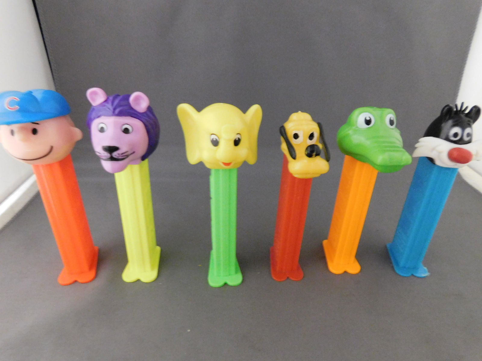 Lot of 6 Mixed Pez: Lot of 6 Mixed Pez. They all have feet. Included in this lot are Pluto, Charlie Brown, Sylvester, and 3 animals. You are bidding at a live sale, please read the terms and conditions. We are offering c