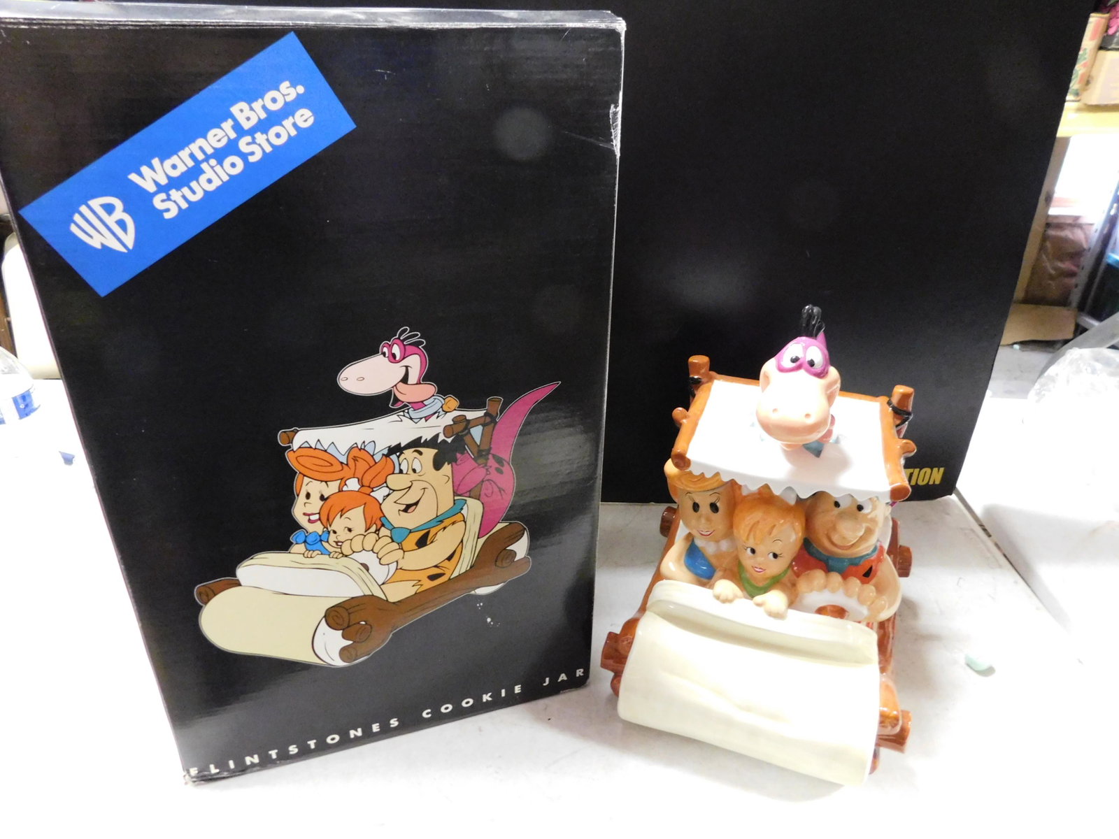 The Flintstones Cookie Jar: The Flintstones Cookie Jar. Warner Bros Studio Store. 1999. Measures approx 13.5" tall. Comes in Box. You are bidding at a live sale, please read the terms and conditions. We are offering contact-less