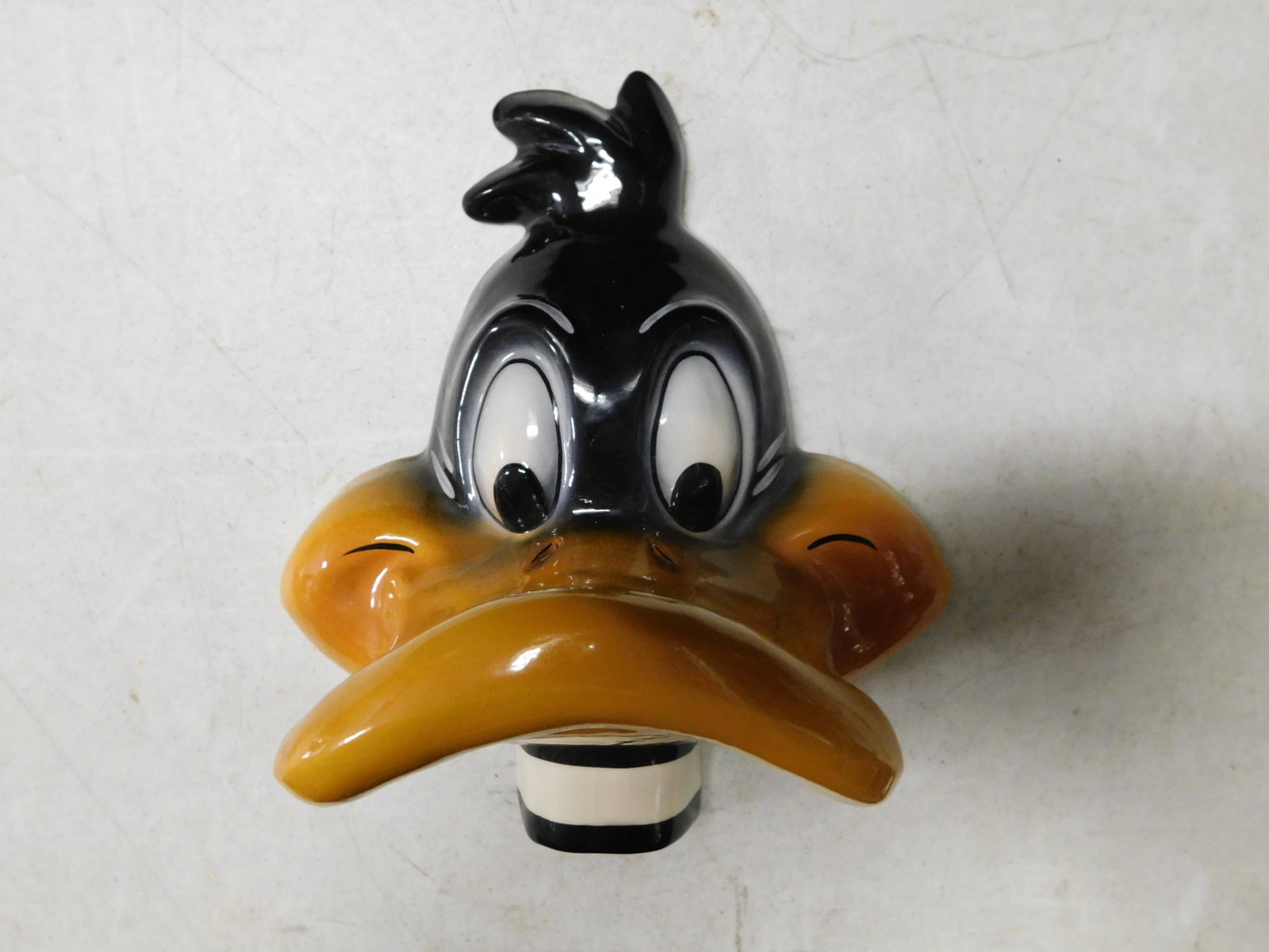 Daffy Duck Wall Pocket: Daffy Duck Wall Pocket. Warner Bros 1986. Some crazing present. Measures approx. 11" long. You are bidding at a live sale, please read the terms and conditions. We are offering contact-less pick ups a