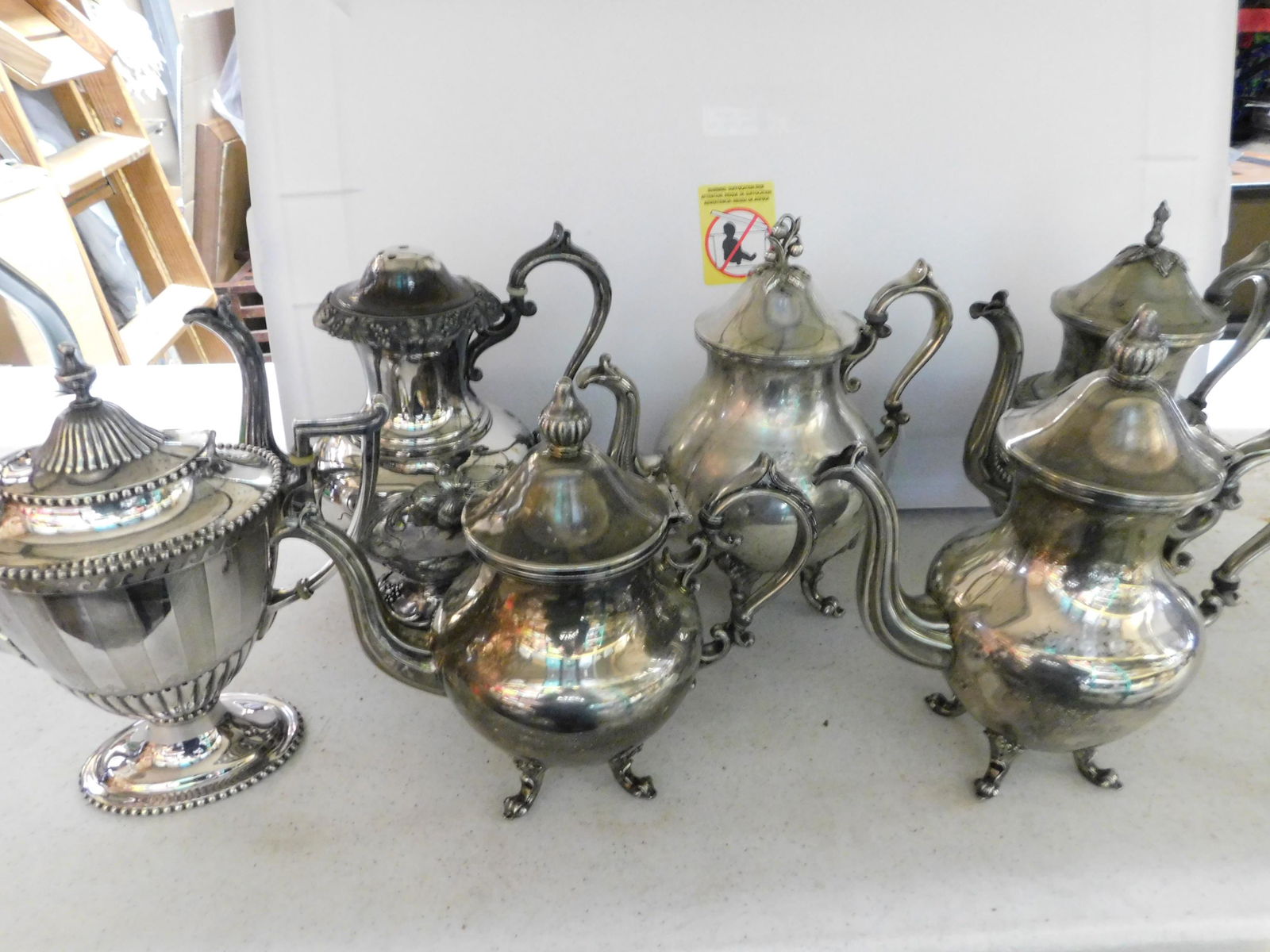 Box Lot of Silver-plate Teapots: Box Lot of Silver-plate Teapots. You are bidding at a live sale. Please read the terms and conditions. This sale will be broadcast live on sale day with full descriptions of each lot being sold, as we