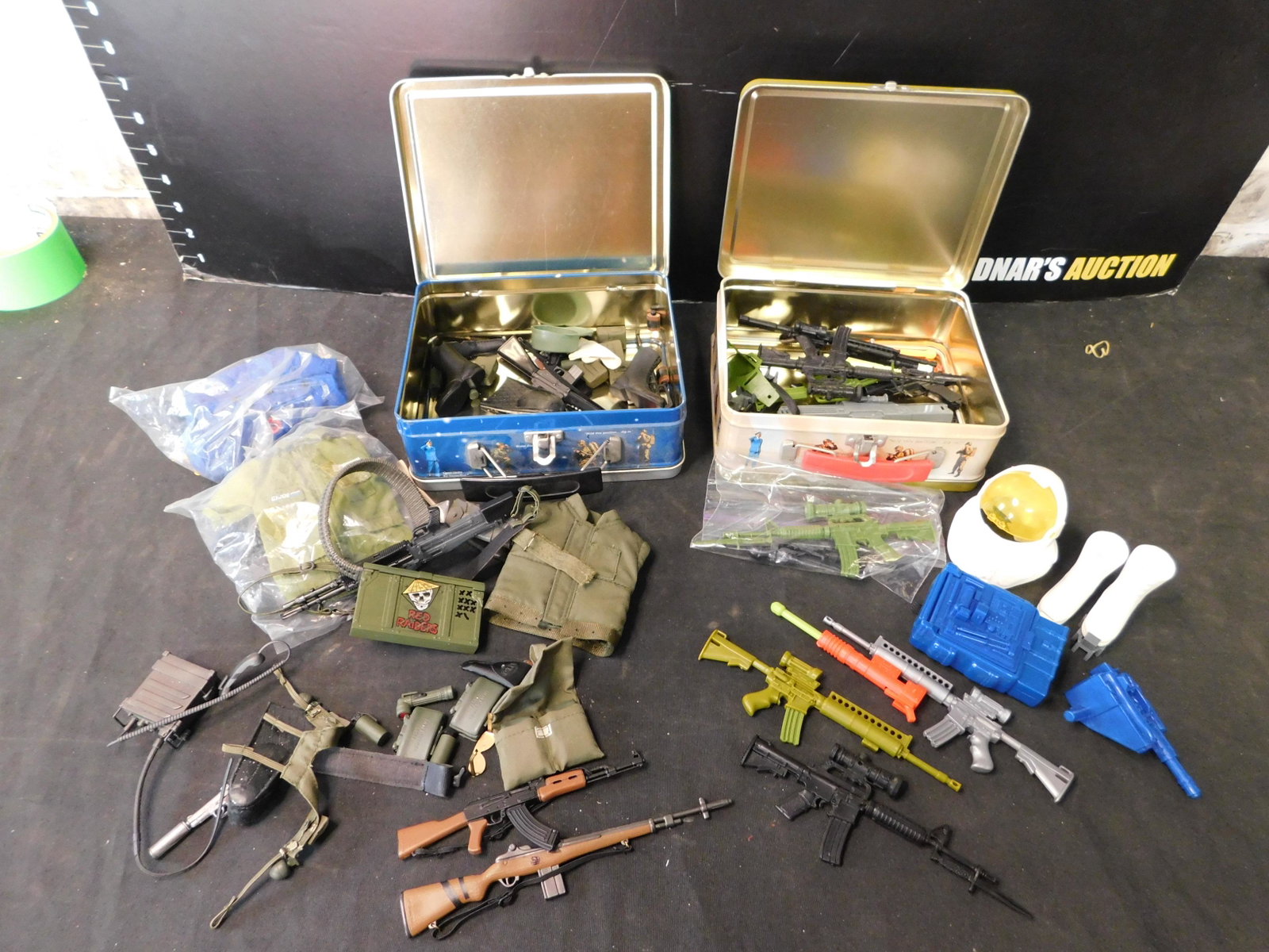 Lot of 2 GI Joe Lunchboxes with: Lot of 2 GI Joe Lunchboxes filled with Clothing/Weapons/Accessories. You are bidding at a live sale, please read the terms and conditions. We are offering contact-less pick ups at our South Brunswick 