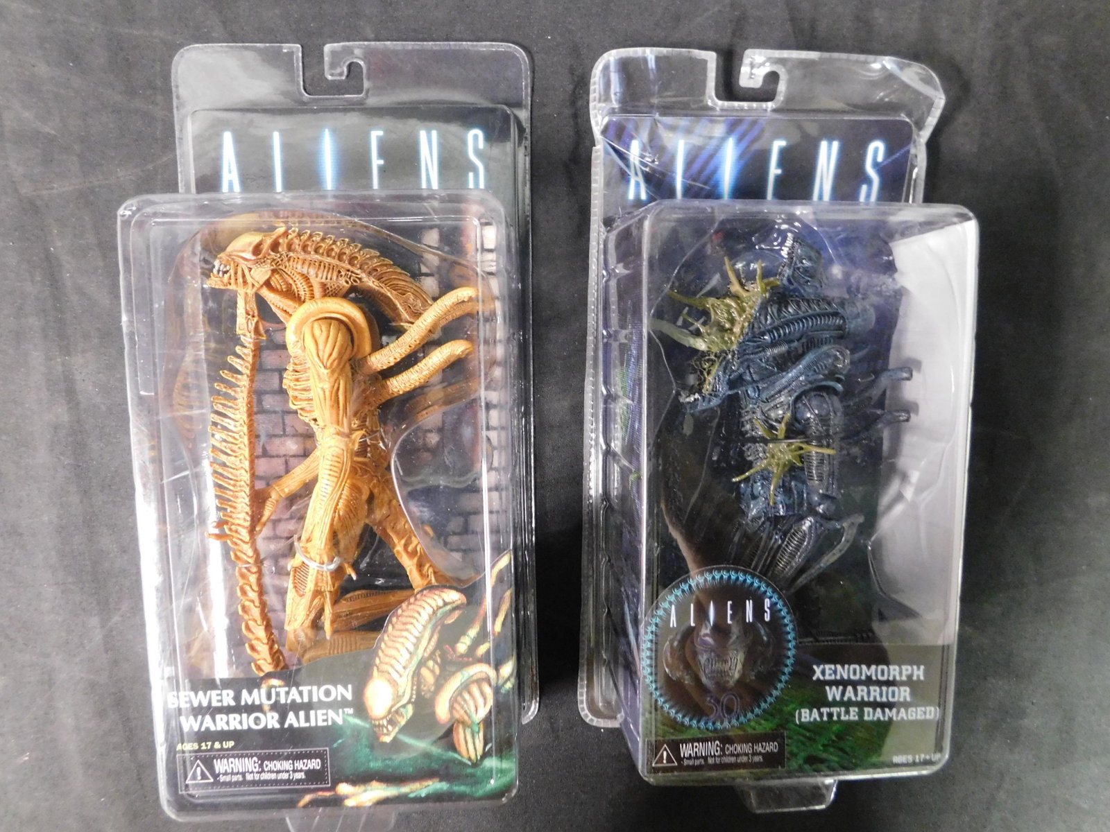 Lot of 2 Neca Alien Action Figures: Lot of 2 NECA Aliens Figures in Package. Included are Xenomorph Warrior (Battle Damaged) and Sewer Mutation Warrior Alien. You are bidding at a live sale, please read the terms and conditions. We are 
