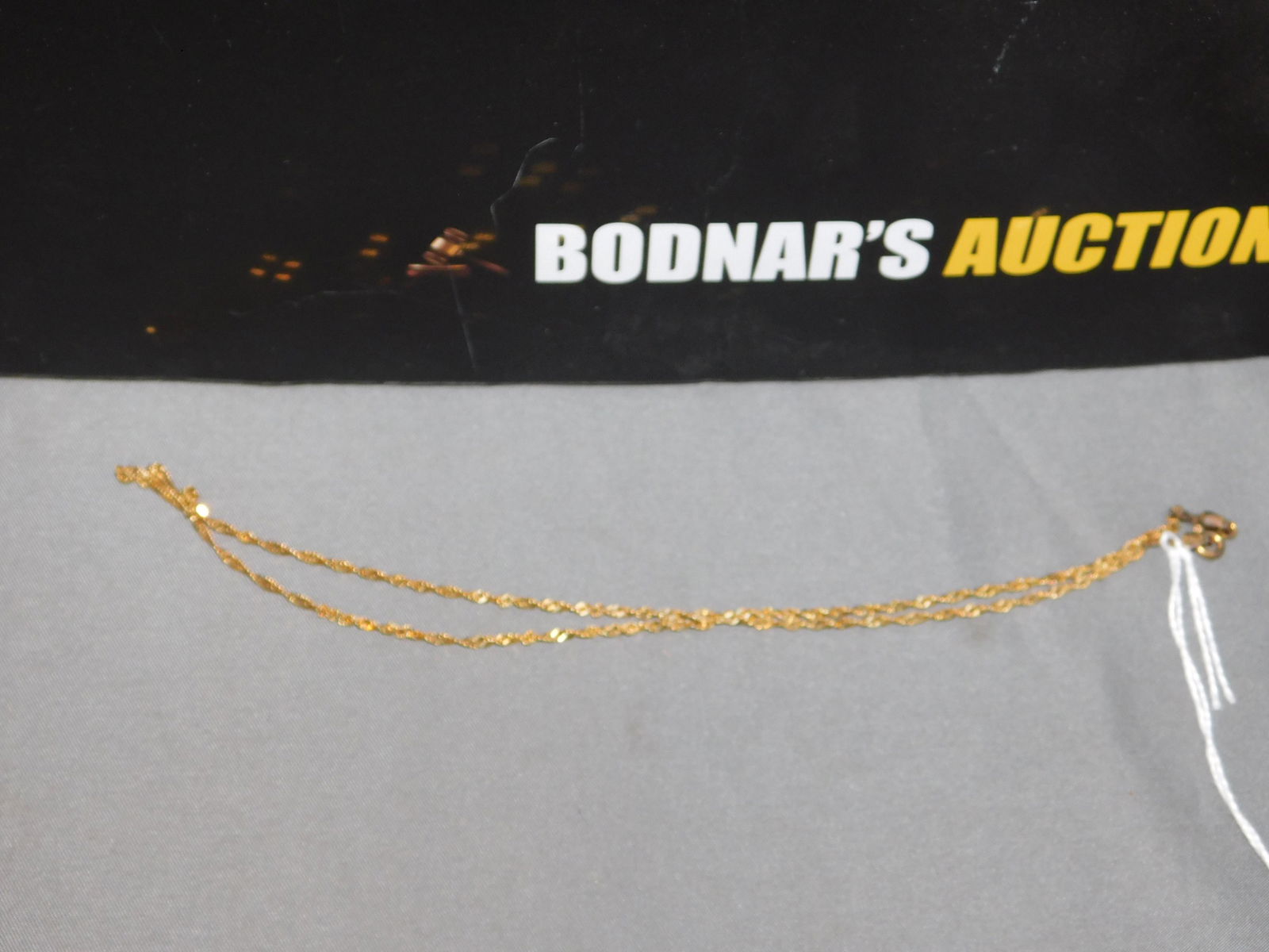 14K Gold Chain Necklace: 14K yellow gold chain necklace. Measures 15.5". Marked near the clasp. Discolored near the clasp. You are bidding at a live sale, please read the terms and conditions. We are offering contact-less pic