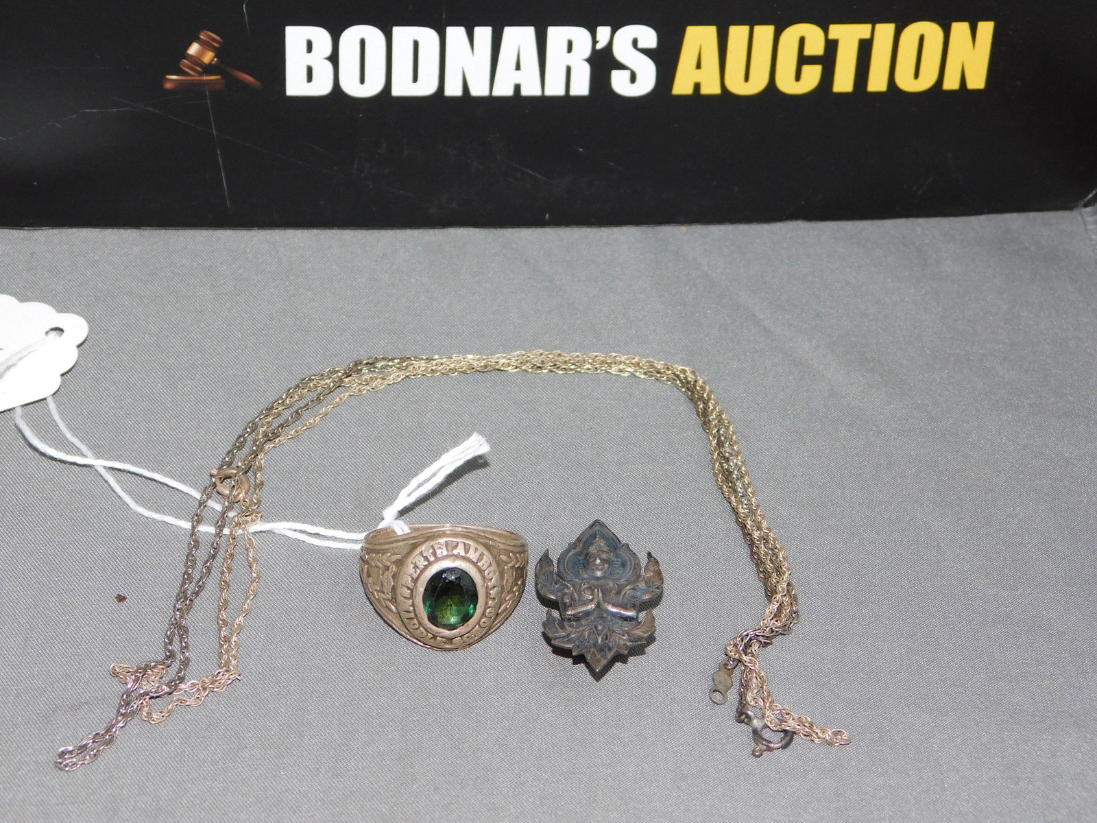Lot of Sterling Jewelry: Lot of sterling silver jewelry. Necklaces measure 19" and 20". School ring from Perth Amboy Middle School is a size 8 3/4. Asian clip measures 1 1/8". Ring is out of shape. You are bidding at a live s