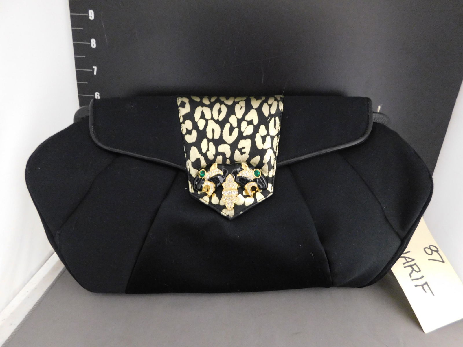 Saharif Black Leopard Clutch: Sharif Black Leopard Clutch. Has Strap inside. Measures 7" T x 13" W. We are offering contact-less pick ups at our South Brunswick location by APPOINTMENT ONLY on the Friday, Saturday, Monday and Tues