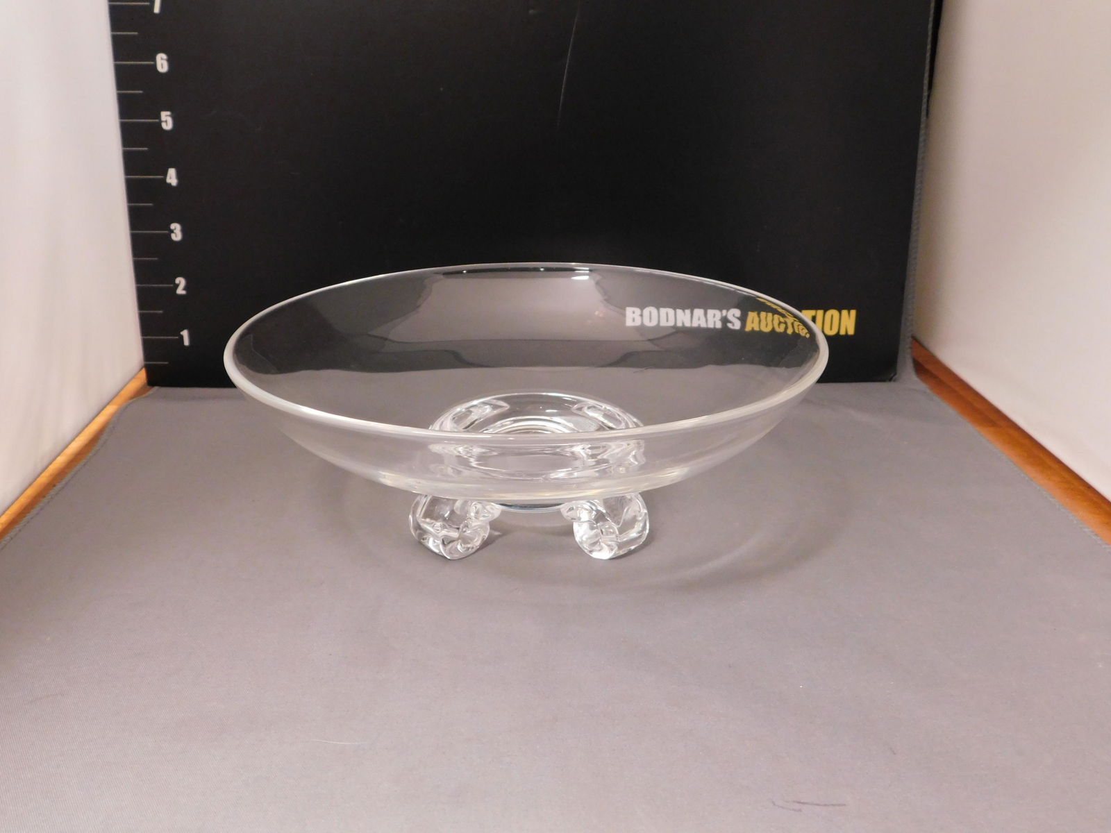 Steuben Art Glass Bowl: Signed Steuben art glass bowl with applied feet. Measures approx. 3" tall x 8" wide. You are bidding at a live sale, please read the terms and conditions. We are offering contact-less pick ups at our