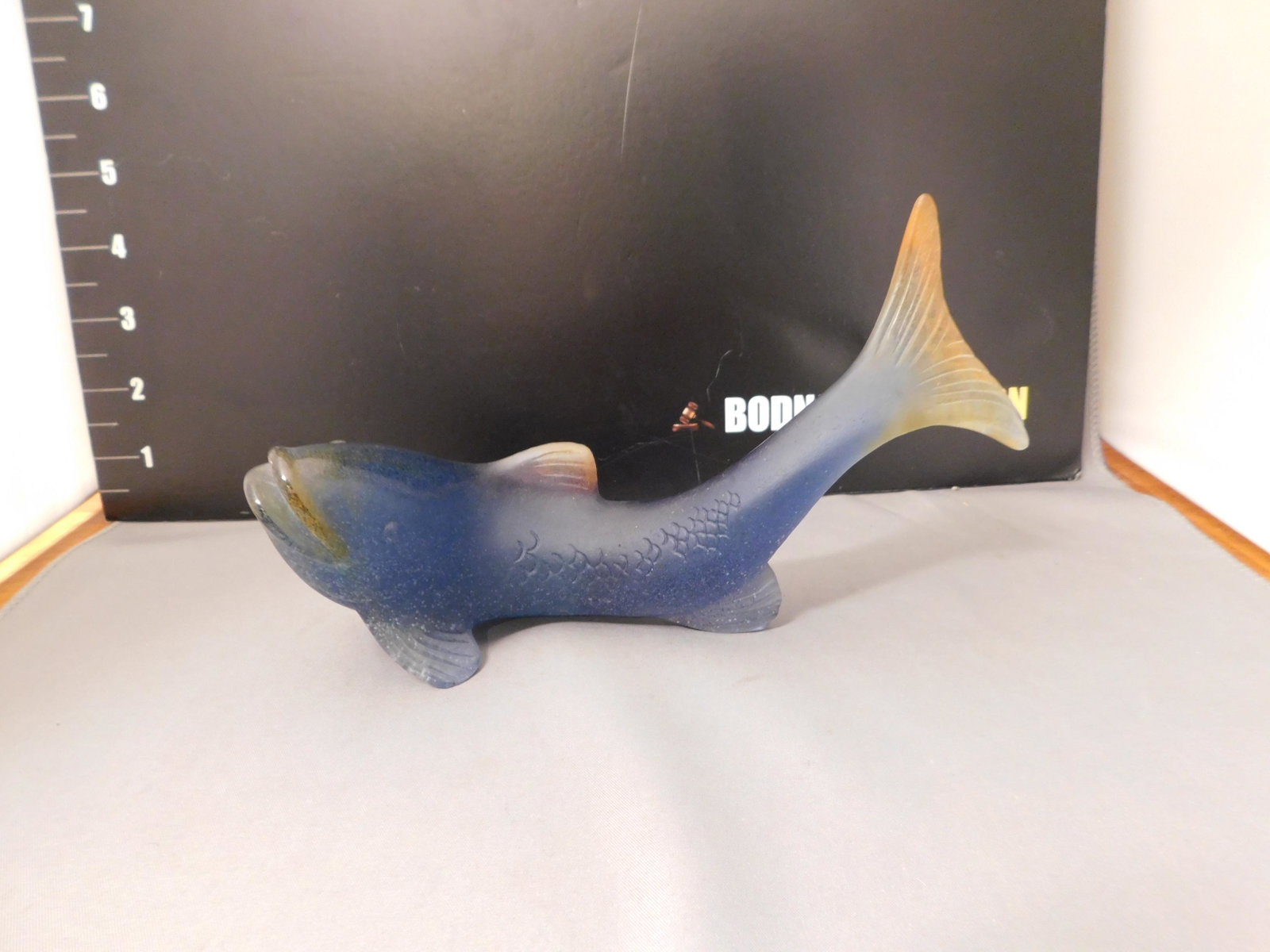 Daum Art Glass Fish: Signed Daum France art glass fish in blue with amber accents in a matte finish. Measures approx. 4 1/4" tall x 7 3/4" wide. You are bidding at a live sale, please read the terms and conditions. We are