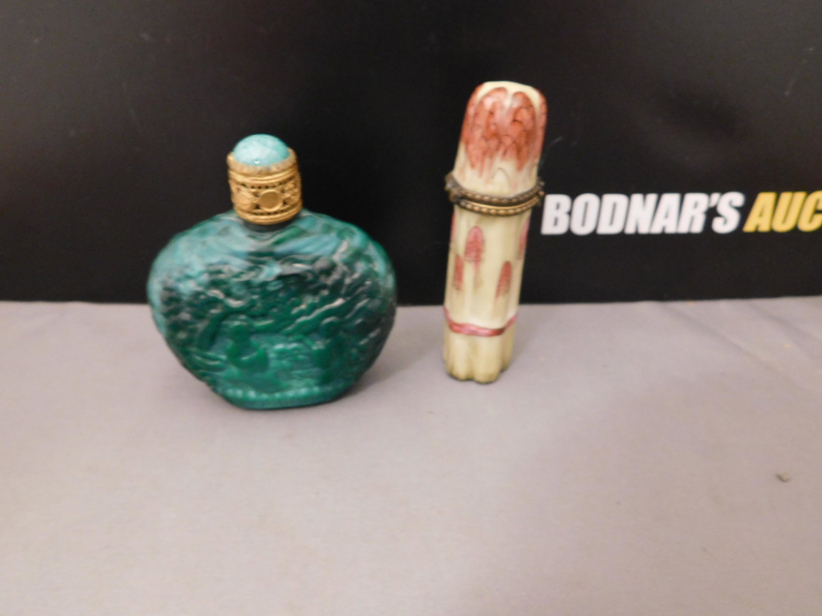 Limoges Trinket box and Snuff Bottle: Limoges France trinket box shaped as asparagus and a green glass snuff bottle. You are bidding at a live sale, please read the terms and conditions. We are offering contact-less pick ups at our South 