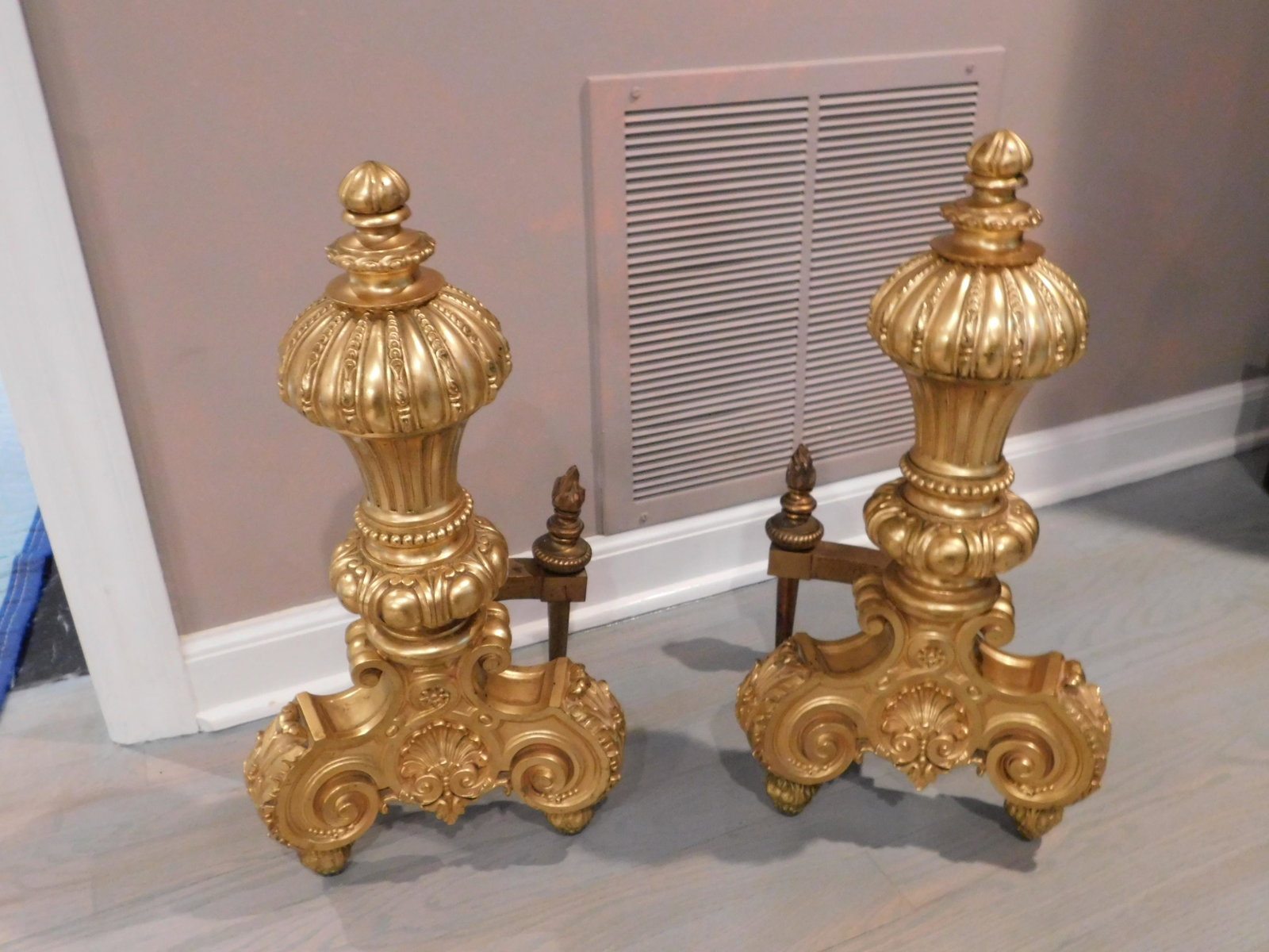 Pair of Gold Gilded Andirons: Pair of gold gilded decorative andirons. Measures approx. 19" tall x 8" wide. You are bidding at a live sale, please read the terms and conditions. We are offering contact-less pick ups at our South B