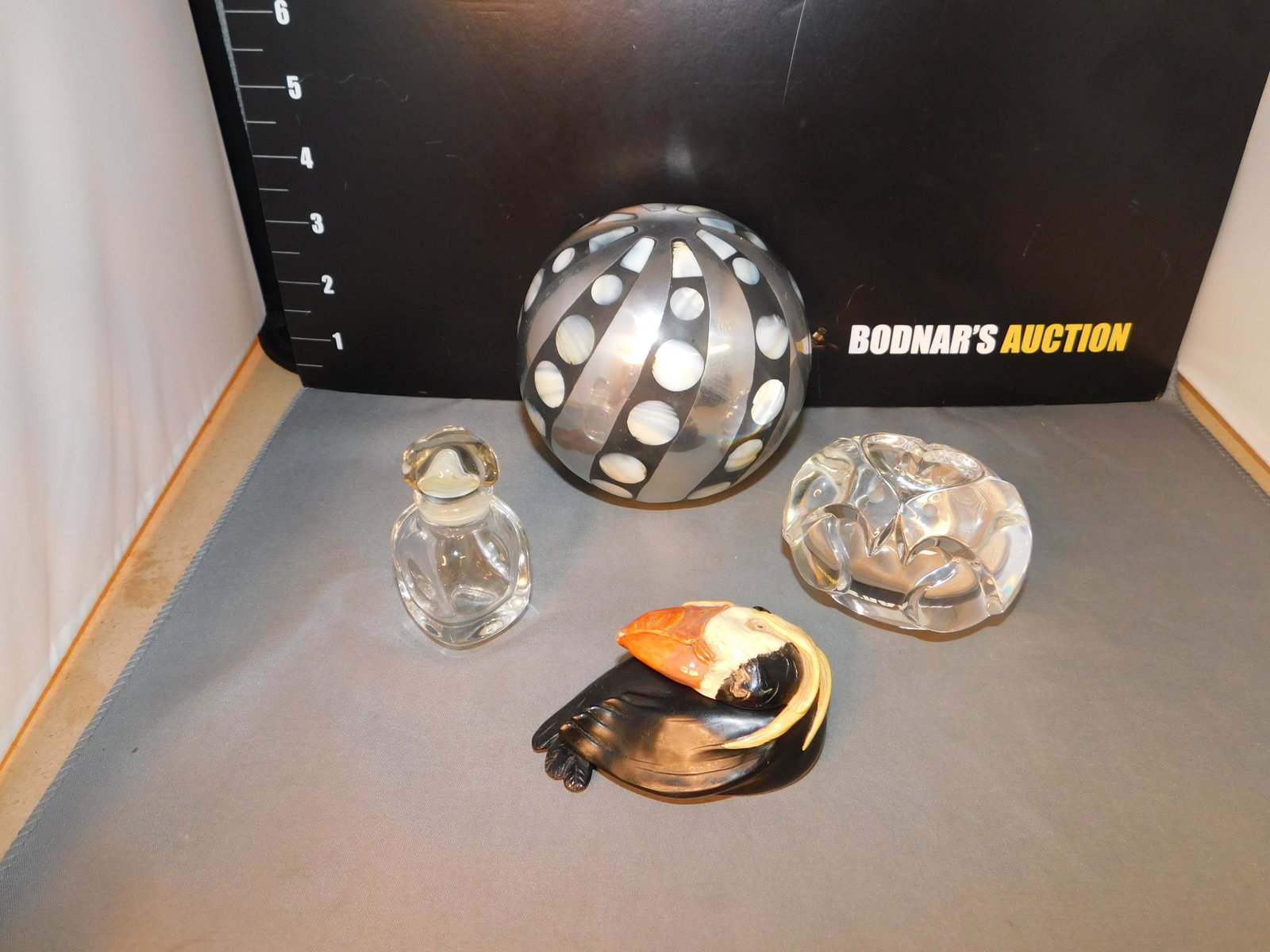 Lot of 4 Art Glass Pieces: Lot of 4 art glass pieces including a Givenchy perfume bottle, paperweight, a resin puffin box signed Ralph Massey and a silver and mother of pearl ball. You are bidding at a live sale, please read th