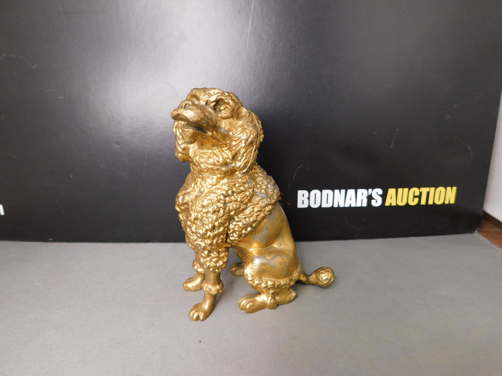 Cast Metal Dog Figurine: Cast Metal Dog Figurine. Has Gold Gilt Paint. Measures 4.5" tall. You are bidding at a live sale, please read the terms and conditions. We are offering contact-less pick ups at our South Brunswick loc