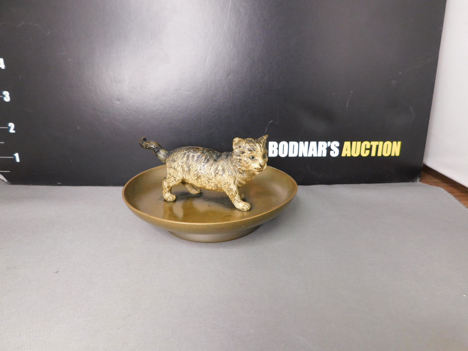 Brass and Mixed Metal Kitten on Dish: Brass and Mixed Metal Cold Painted Kitten on Dish. Measures 2.25" t x 4.25" d. You are bidding at a live sale, please read the terms and conditions. We are offering contact-less pick ups at our South