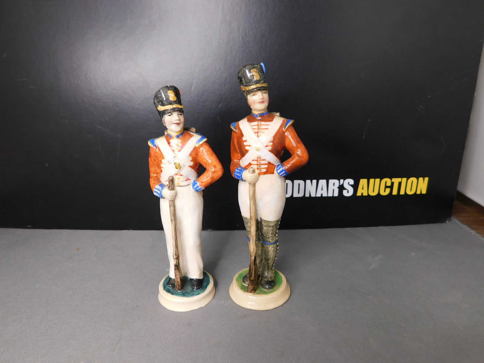 Lot of 2 Dulwich Pottery Figurines: Lot of 2 Dulwich Art Pottery Figurines - English Soldiers. Measures 4.25" - 4.5" tall. You are bidding at a live sale, please read the terms and conditions. We are offering contact-less pick ups at ou