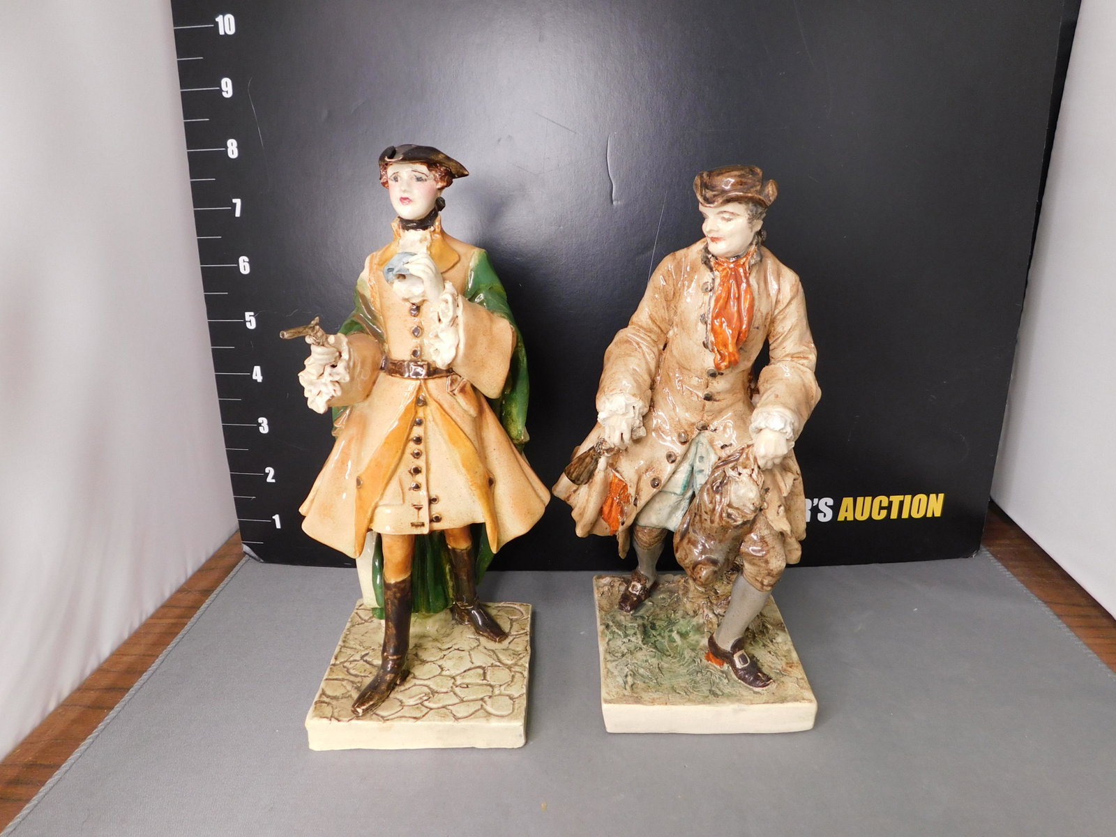 Lot of 2 English Pottery Men Statues: Lot of 2 English Art Pottery Men Statues. One has pistol and the other has game and shotgun. Marked MB 1937 1938. One As-Is Missing Shotgun. Measures 7.5" - 8" tall. You are bidding at a live sale, pl