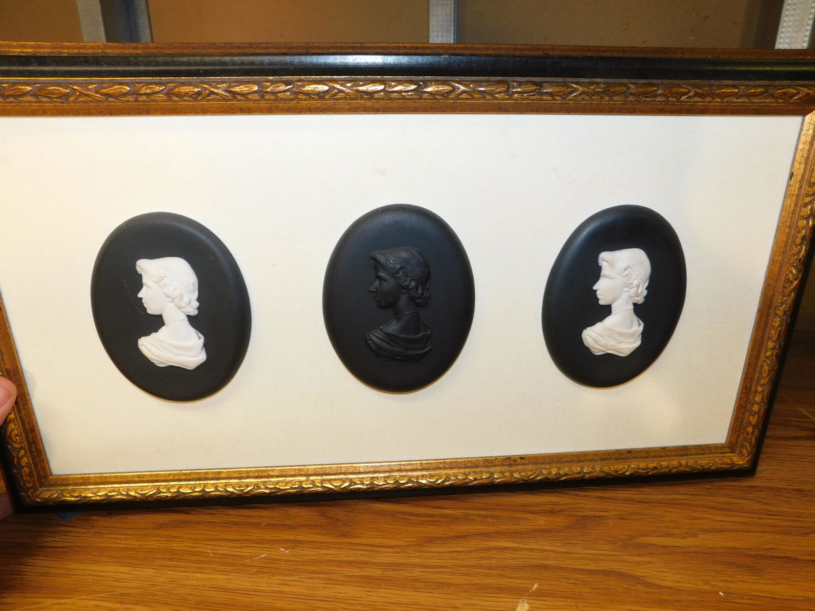 Framed Collage of 3 Porcelain Plaques: Framed Collage Of Black Jasper - Appears to be Wedgewood. Measures 10" x 19". You are bidding at a live sale, please read the terms and conditions. We are offering contact-less pick ups at our South B