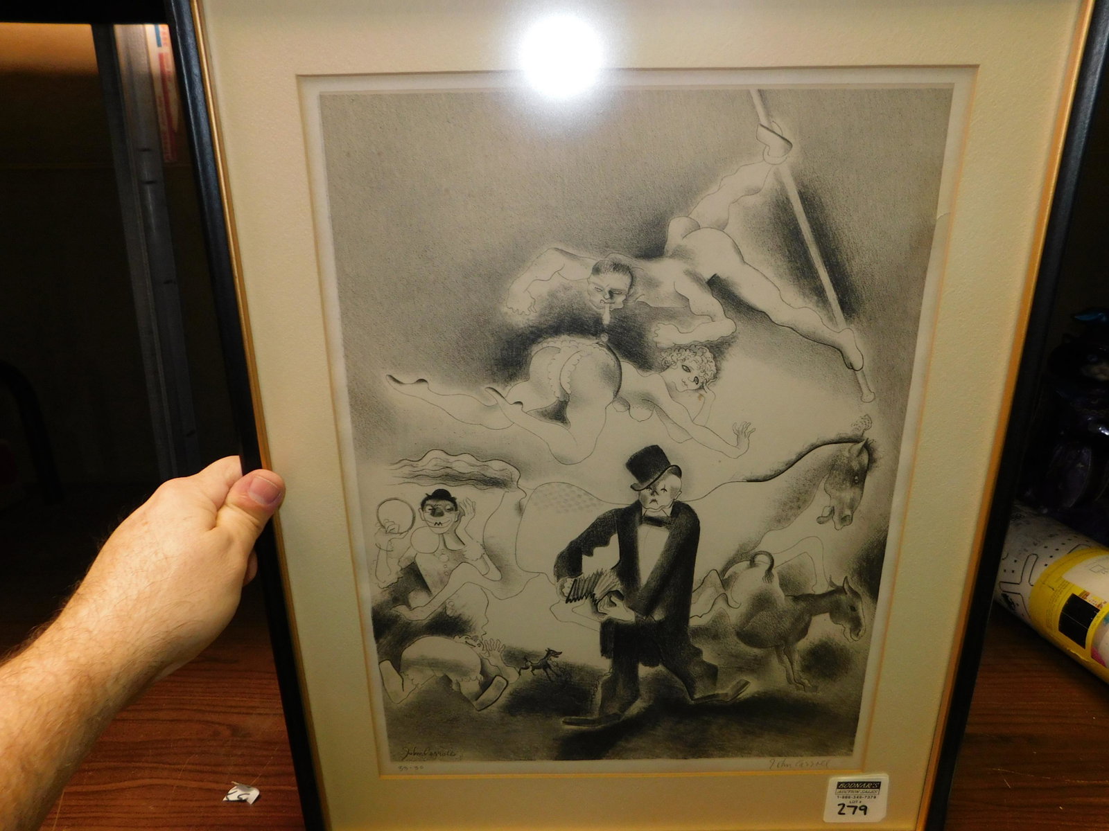 Art Deco Lithograph of a Comical Scene: Framed Art Deco Lithograph Signed lower right John Carroll. Marked Lower Left 33-30. Depicting a comical scene with clowns and donkey. Image measures 16" tall x 12" wide. You are bidding at a live sal
