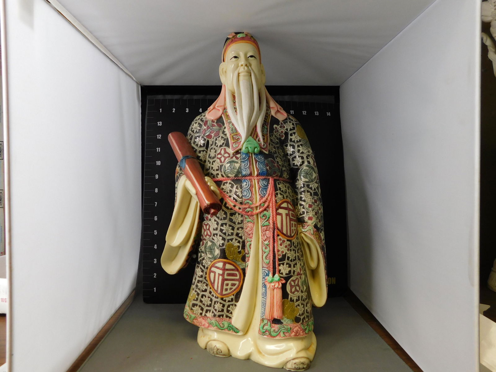 Resin Asian Figurine: Resin Old Wise Asian Man in Hand carved and Painted Ornate Robe with Scroll. Measures 17" tall. You are bidding at a live sale, please read the terms and conditions. We are offering contact-less pick