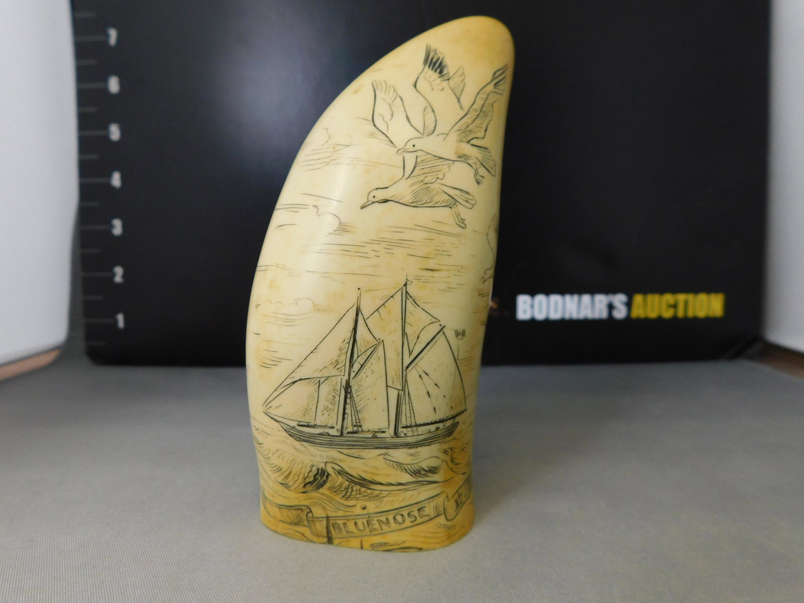 Souvenir Scrimshaw: Souvenir Scrimshaw. The Blue Nose II. Nova Scotia. Comes in a box with tag that says Made in Britain. Measures 4.25" tall. You are bidding at a live sale, please read the terms and conditions. We are 