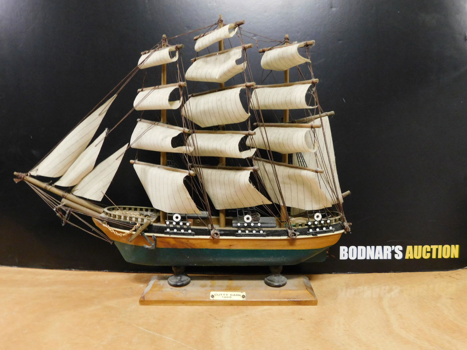 Model Ship of Cutty Sark: Model Ship - "Cutty Sark" 1.869. Needs some cleaning. Overall good condition. Measures 16" tall x 20" long. You are bidding at a live sale, please read the terms and conditions. We are offering contac