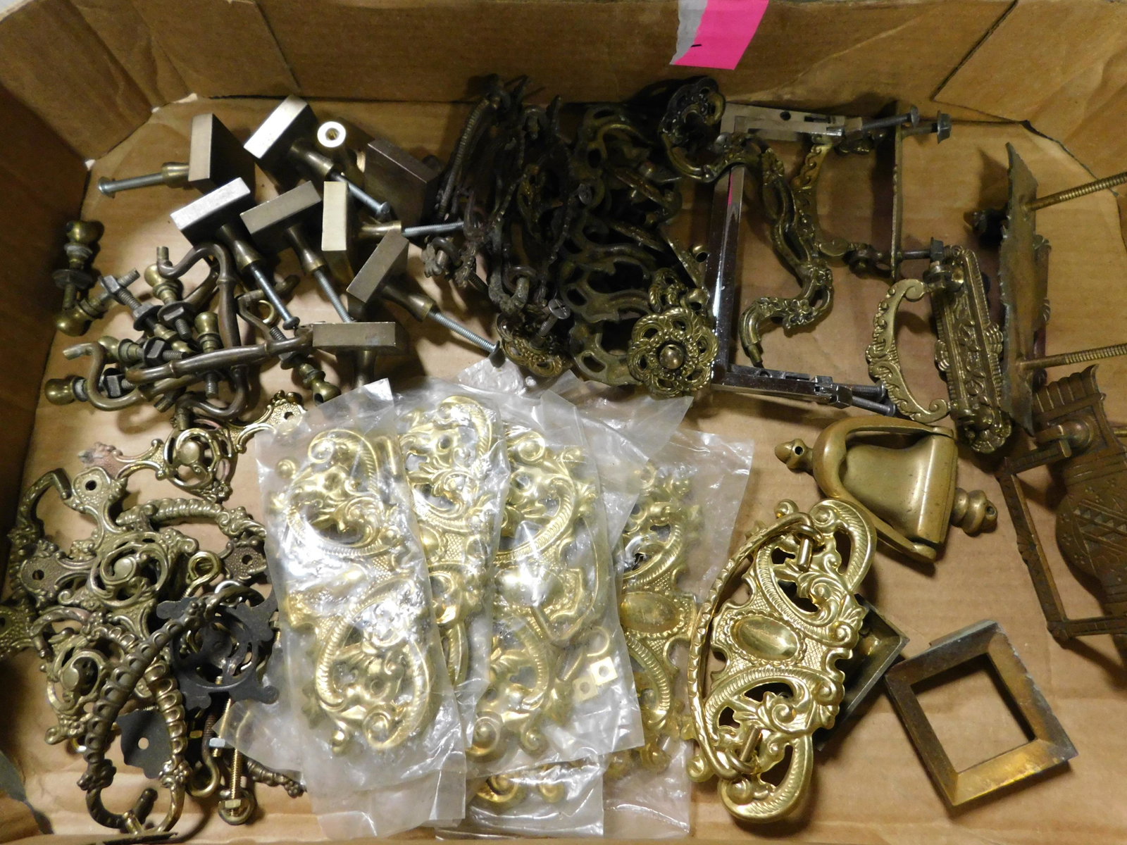 Box Lot of Brass Furniture Hardware: Box Lot of Brass Furniture Hardware. This sale will be broadcast live on sale day with an auctioneer and caller calling full descriptions of each lot being sold, as well as video feed of each lot. All