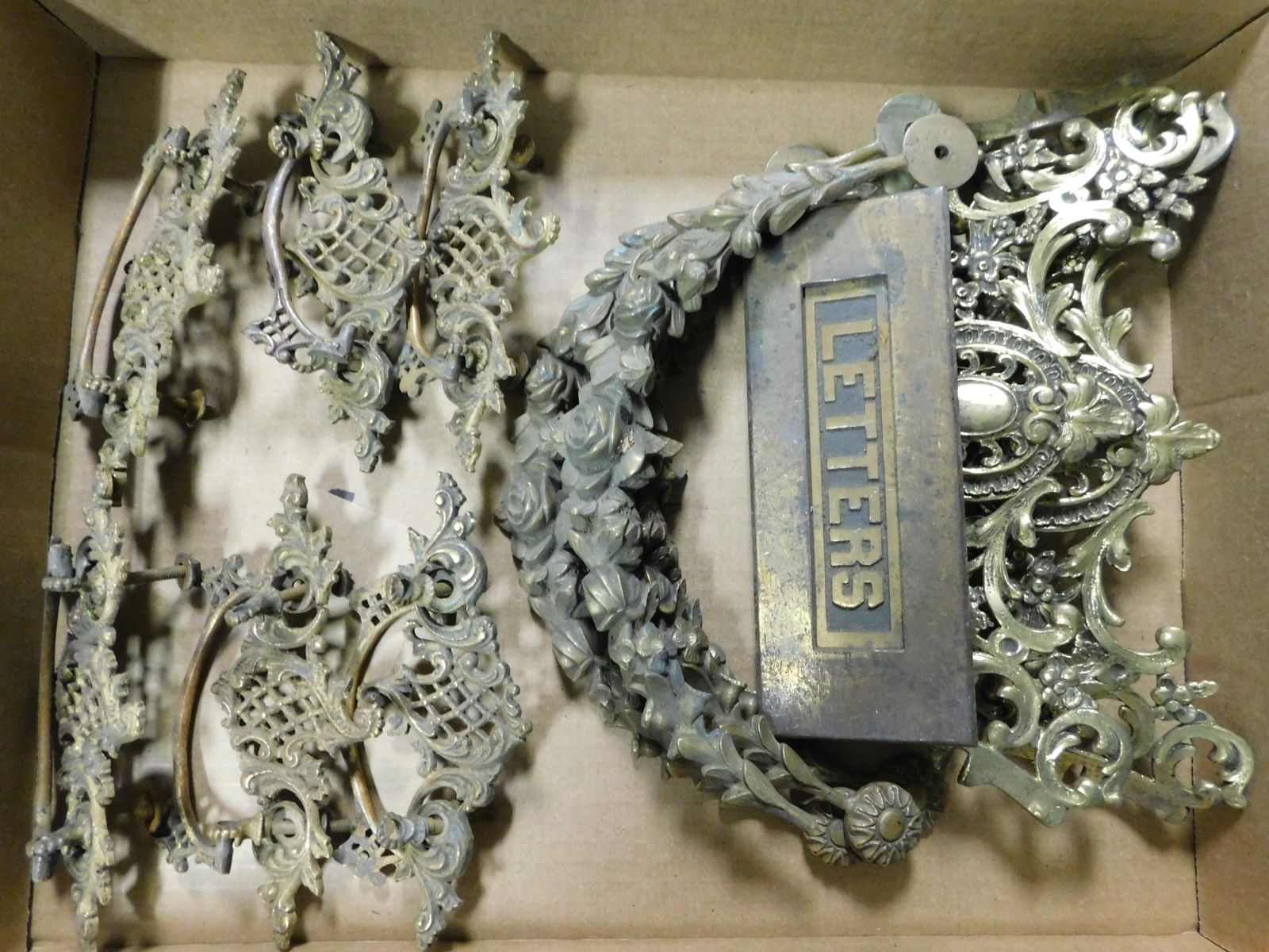 Box Lot of Brass Furniture Hardware and Swags: Box Lot with Brass Furniture Hardware and Decorative Swags. This sale will be broadcast live on sale day with an auctioneer and caller calling full descriptions of each lot being sold, as well as vide