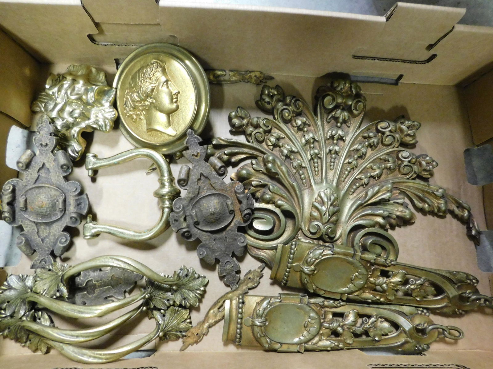 Box Lot of Brass Furniture Hardware: Box Lot with Brass Furniture Hardware - Many Ornate Pieces. This sale will be broadcast live on sale day with an auctioneer and caller calling full descriptions of each lot being sold, as well as vide