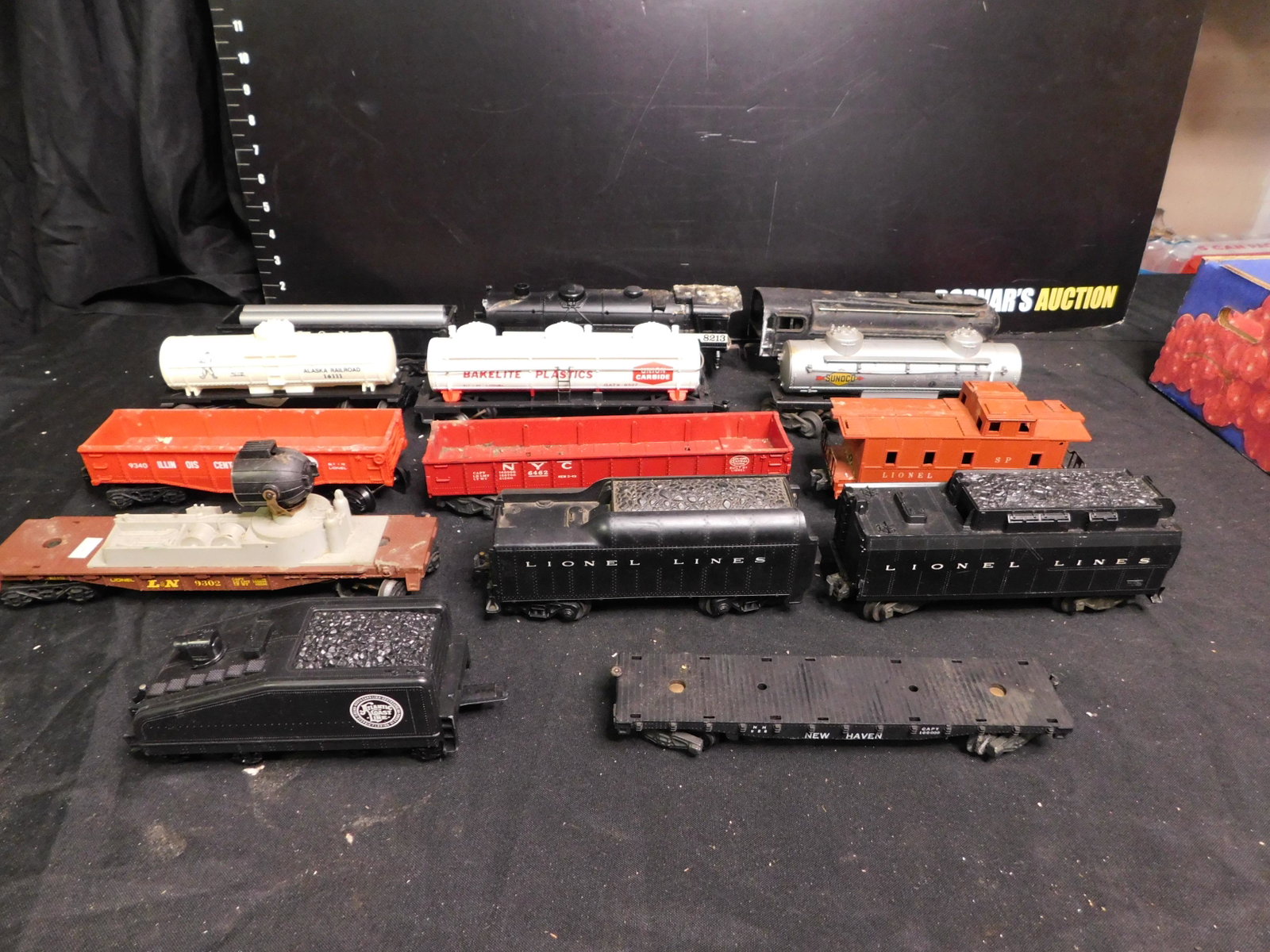 Lot of 14 Trains - Mostly Lionel: Lot of 13 Lionel Trains and 1 American Flyer. Included in this lot is an American Flyer New Haven Flatcar 928. Also included Lionel; 3 Non Whistling Tenders, Searchlight Car 9302, Caboose 6357, NYC Go