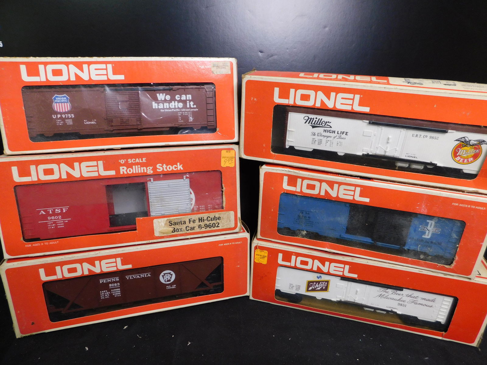 Lot of 6 Lionel Rolling Stock in Boxes: Lot of 6 Lionel Rolling Stock in Boxes. Included are Union P Box Car 9755, Santa Fe Box Car Hi-Cube 9602, Pennsylvania 4 Bay Hopper 9263, Boston and Maine Box Car 9768, Miller High Life Beer Car 9852
