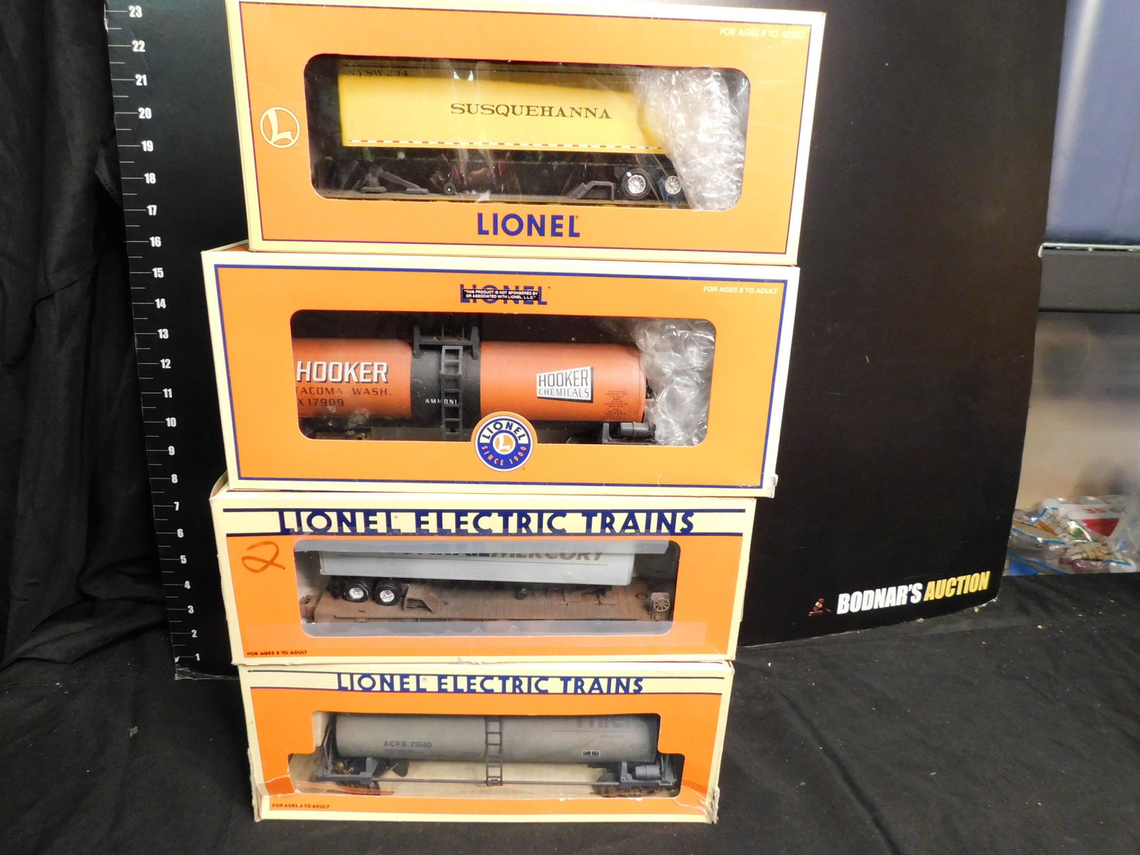 Group Lot of 4 Train Cars: Group Lot of 4 Train Cars. Included are Flatcar Susquehanna Trailer, Lionel Hooker 1 Dome Tank Car 17909, Flatcar with Conrail Mercury Trailer, Thiele 1 Dome Tank Car Weathered. You are bidding at a l