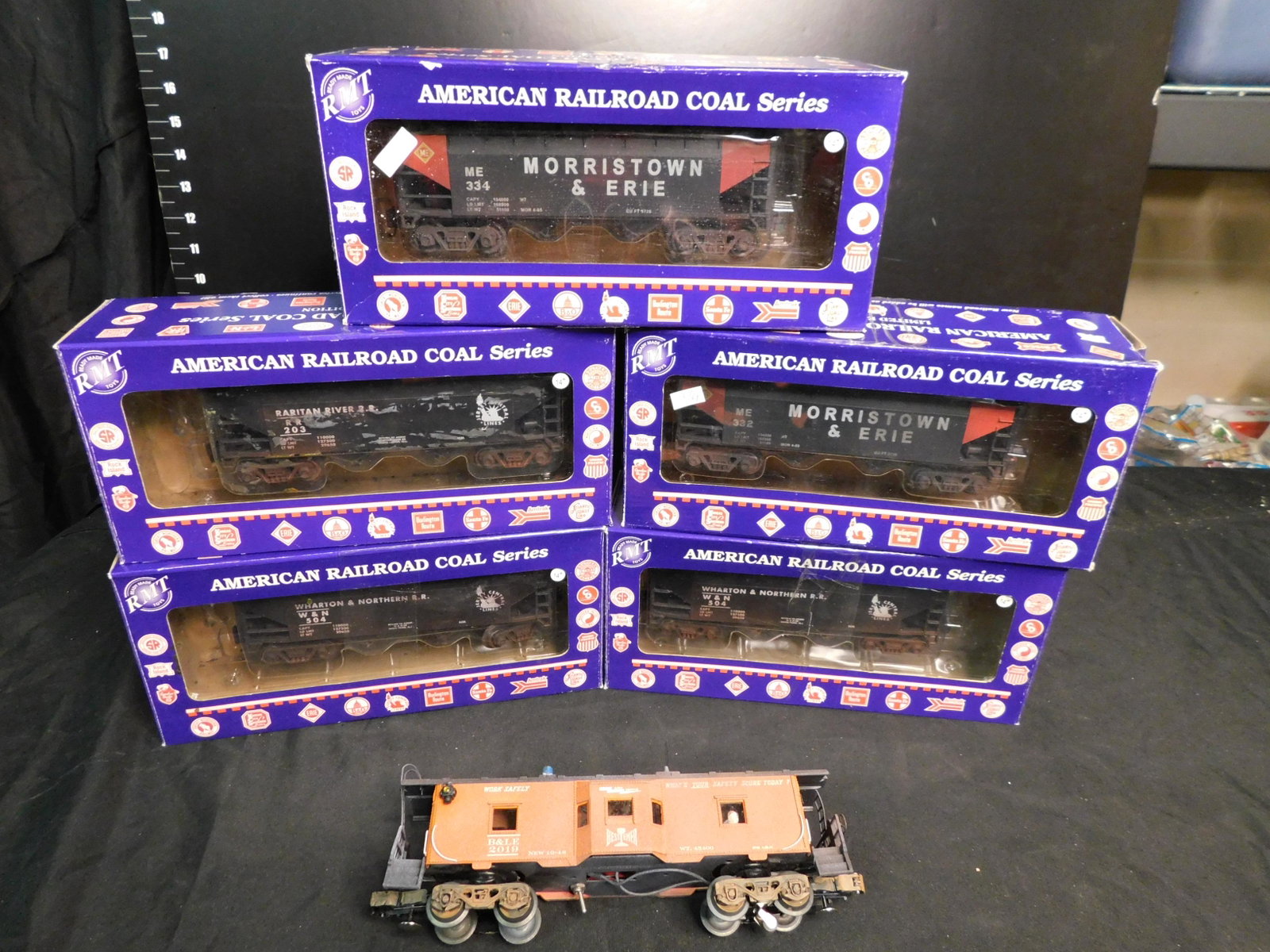 Group Lot of RMT Railroad Cars and Lionel Caboose: Group Lot of 6 Train Cars including 5 RMT American Railroad Coal Series and 1 Weathered and Customized Lionel Bay Window Caboose with Lights and Smoke. You are bidding at a live sale, please read the 