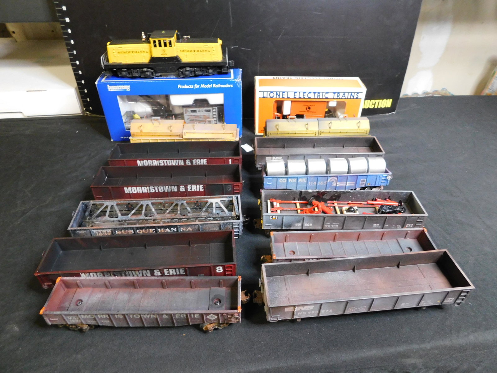 Lot of 15 Train Cars and Trucks: Lot of 14 Train Cars and 1 Truck including Lionel 44 Ton Switcher Susquehana Customized, Industrial Rail Work Caboose Customized, Lionel On Track Step Van and 12 x Assorted Gondolas. You are bidding a