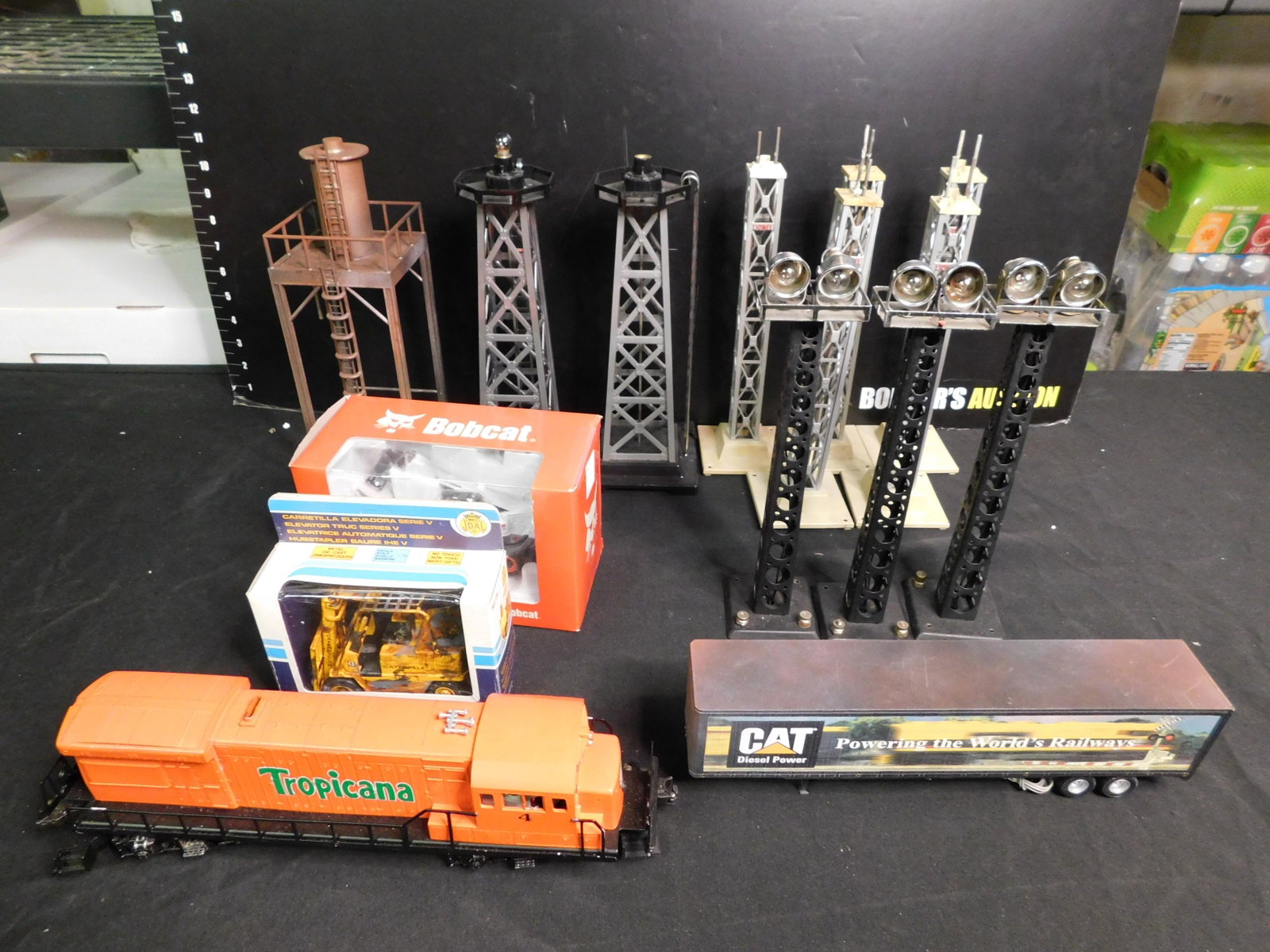 Lot of Train Cars and Accessories including Lionel: Lot of Train Cars and Accessories including Lionel Diesel Engine Customized for Tropicana - Tested and Running, Lionel Sand tower 14255 Painted Brown - In Box, MTH Trailer for CAT Diesel, Bobcat Teles