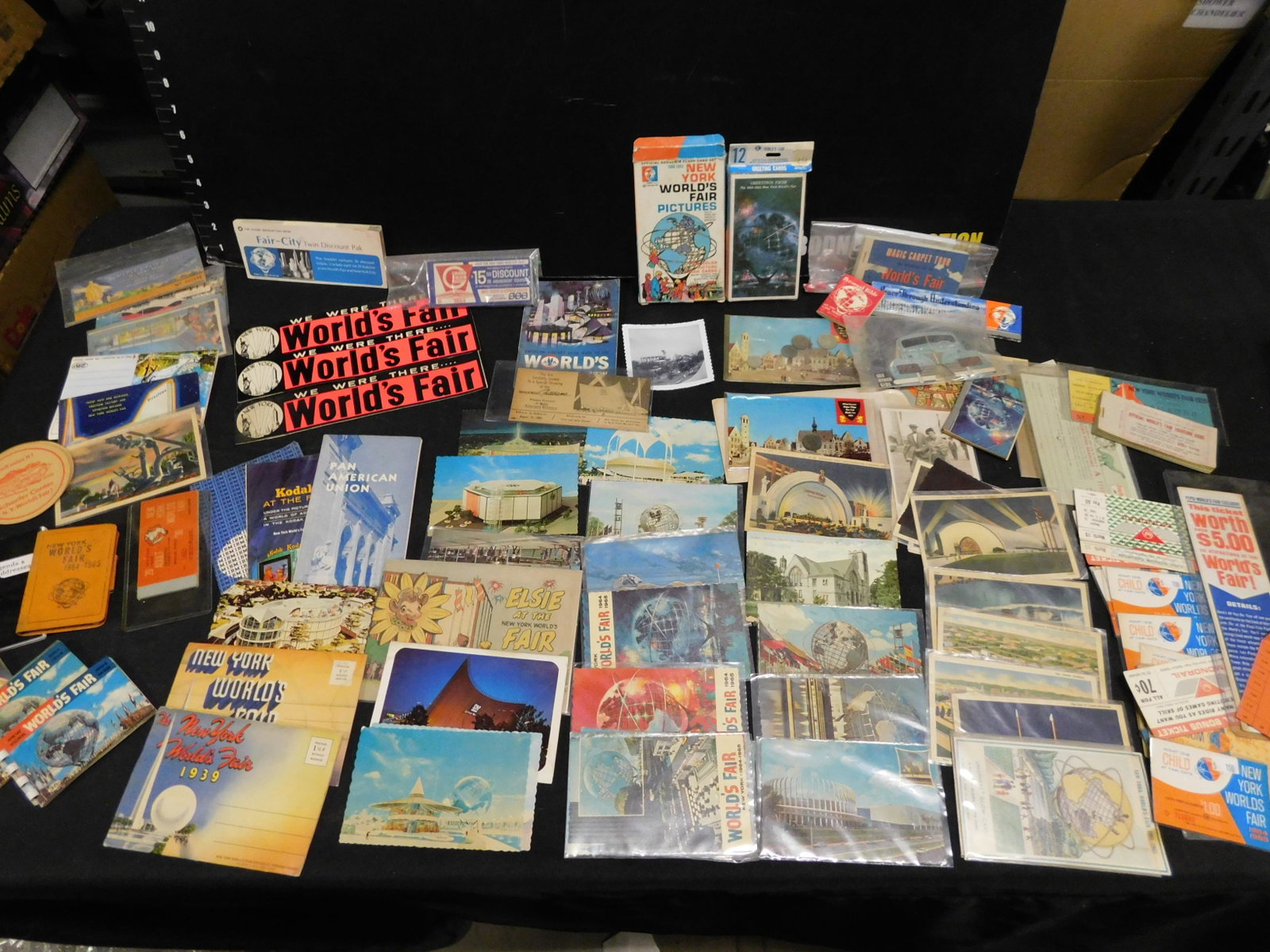 Mixed Lot of 1964 New York World's Fair Ephemera: Mixed Lot of 1964 New York World's Fair Ephemera. Included are some postcards, pictures, bumper stickers and more. This sale will be broadcast live on sale day with an auctioneer and caller calling fu