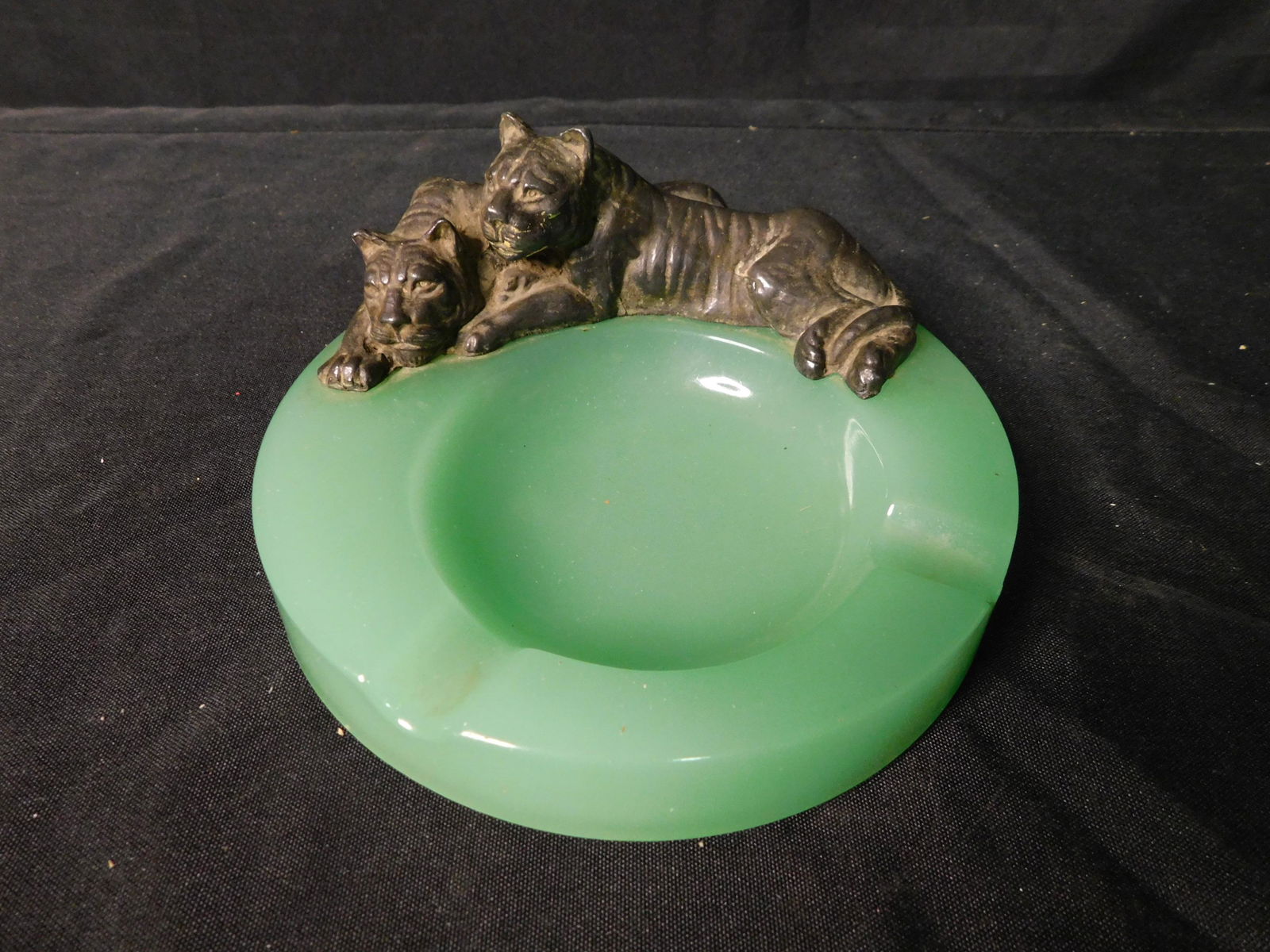 Jadeite Green Glass Ashtray with Tigers: Jadeite Green Glass Ashtray with Tigers. Measures 6" diameter. This sale will be broadcast live on sale day with an auctioneer and caller calling full descriptions of each lot being sold, as well as v