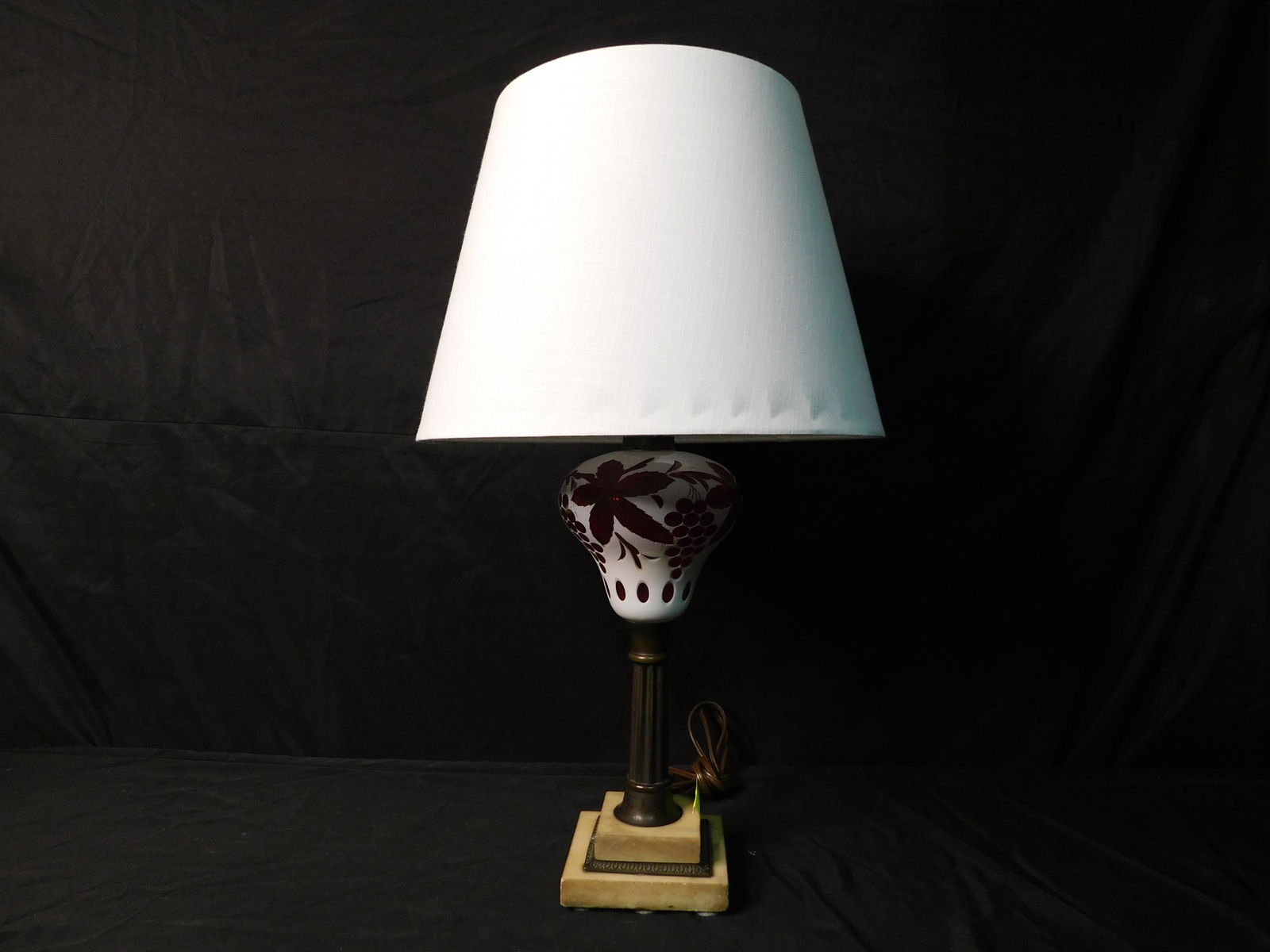 Cut to Cranberry Glass Lamp on Pedestal Base: Cut to Cranberry Glass Lamp on Pedestal Base. Measures 28" tall. This sale will be broadcast live on sale day with an auctioneer and caller calling full descriptions of each lot being sold, as well as