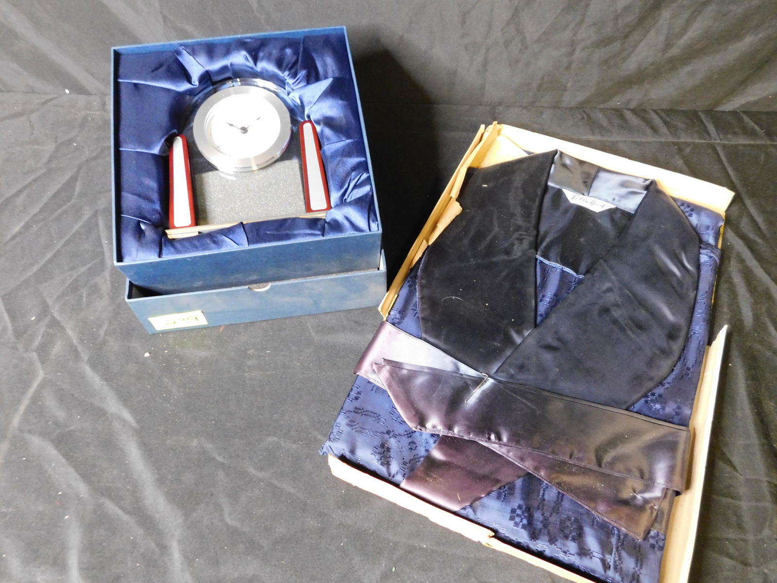 Lot with Chass Clock and Robe: Lot with a Chass Quartz Clock and Robin Hood Size XL Robe. This sale will be broadcast live on sale day with an auctioneer and caller calling full descriptions of each lot being sold, as well as video