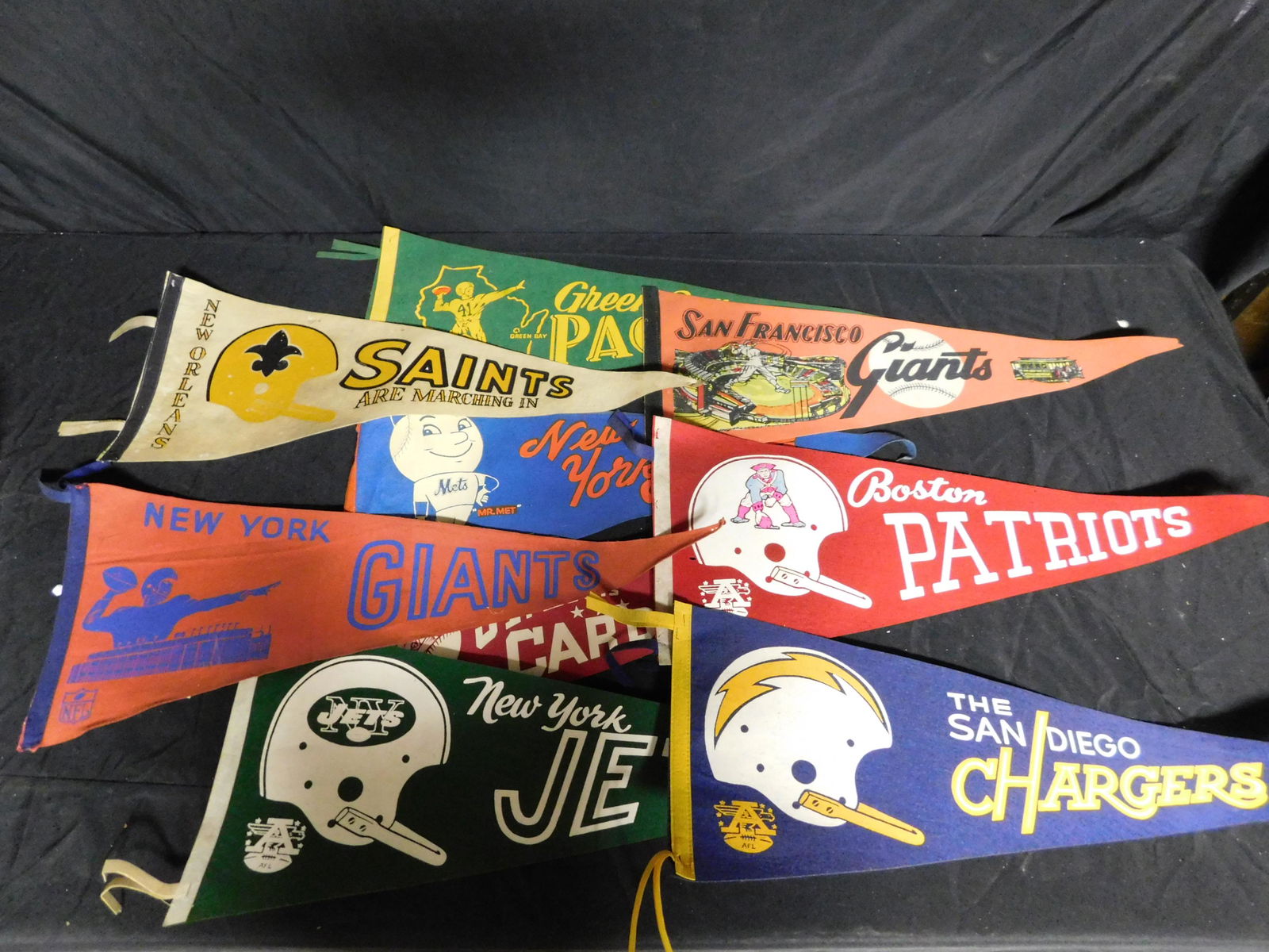 Lot of Sports Related Pennants: Lot of Sports Related Pennants including Packers, Mets, Chargers and More. This sale will be broadcast live on sale day with an auctioneer and caller calling full descriptions of each lot being sold,