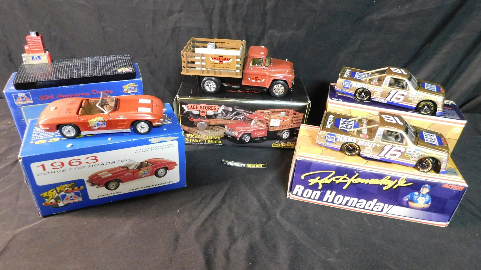 Mixed Lot of Die-Cast Cars: Mixed Lot of Die-Cast Vehicles. Included in this lot are 2 x Ron Hornaday #16 Napa Gold 1997 Chevy Race Trucks, 1957 Chevy Stake Truck, and Big A's 35th Birthday Corvette Roadster with Display Base. W