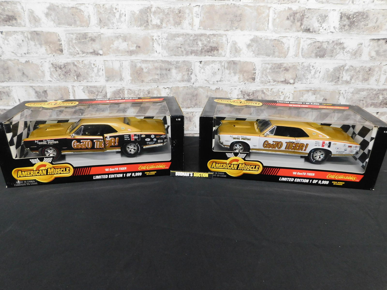 Lot of 2 American Muscle ''66 GeeTo Tiger Die-Cast Cars: Lot of 2 American Muscle ''66 GeeTo Tiger 1:18 Scale Die-Cast Cars. One is Black with Gold and the other is White with Gold. You are bidding at a live sale, please read the terms and conditions. We ar