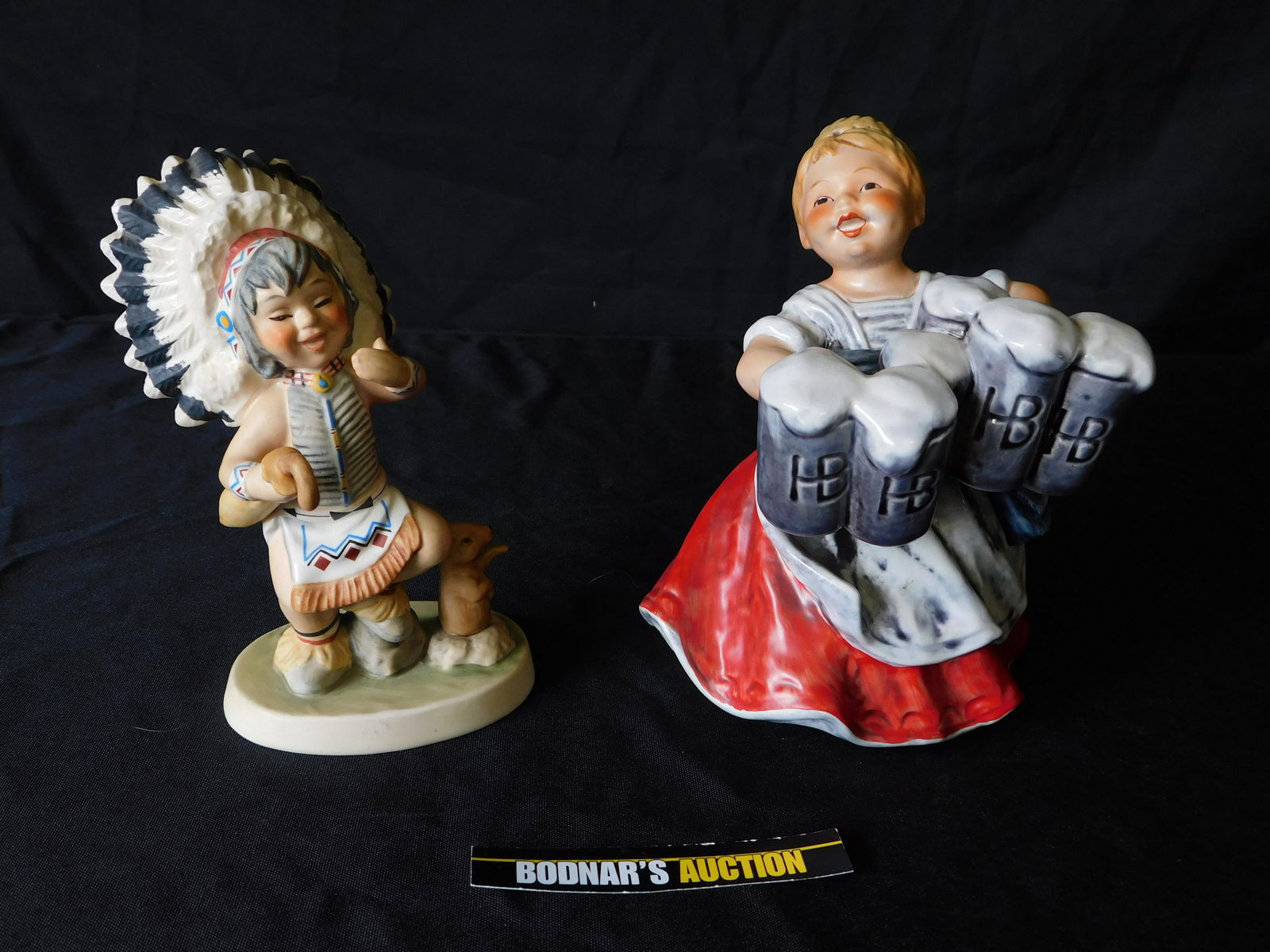 Lot of 2 Goebel Figurines: Lot of 2 Goebel Figurines. Including an Indian and a German Girl with Beer. You are bidding at a live sale, please read the terms and conditions. We are offering contact-less pick ups at our South Bru